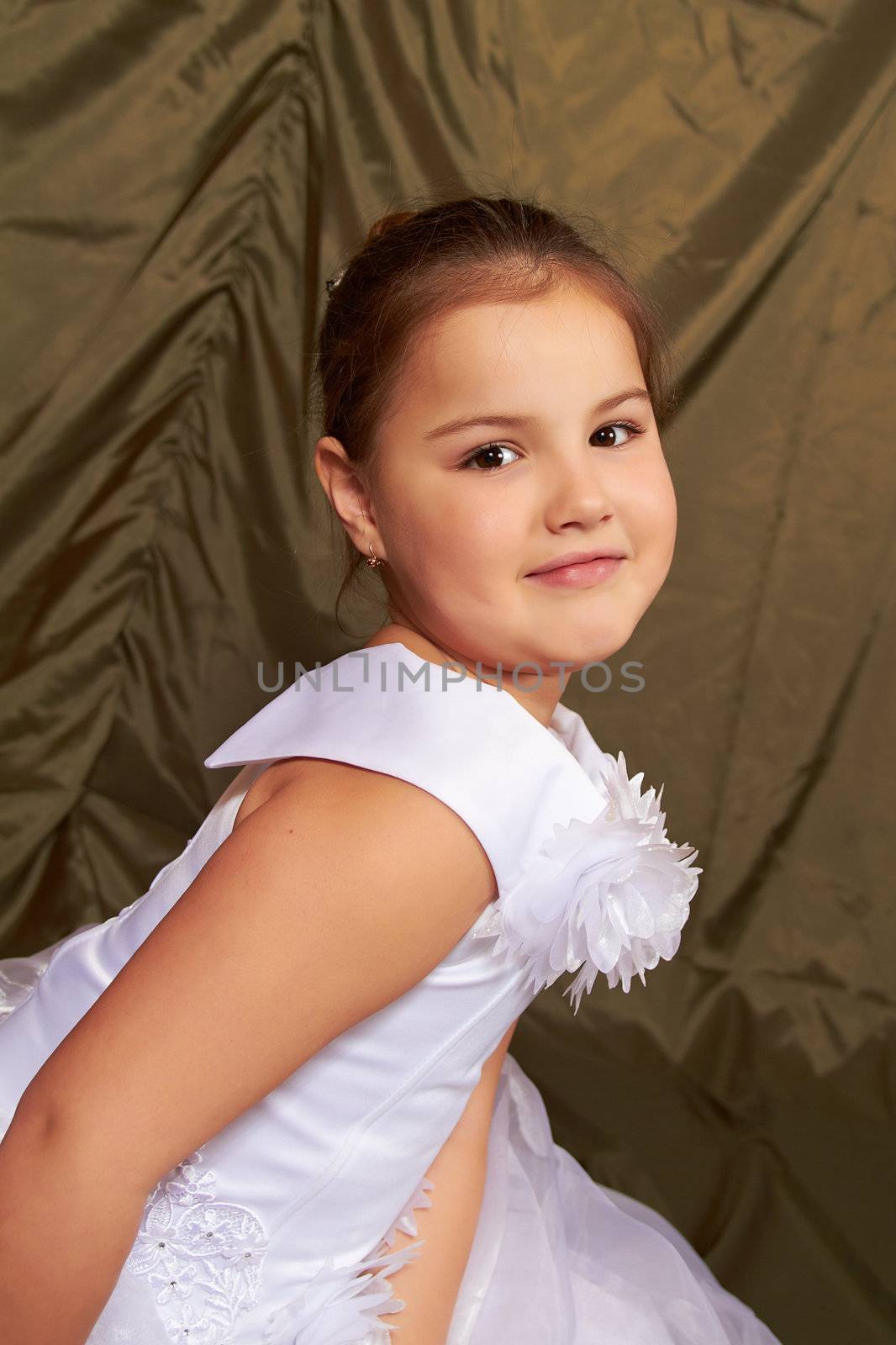 A little girl sits pensively.