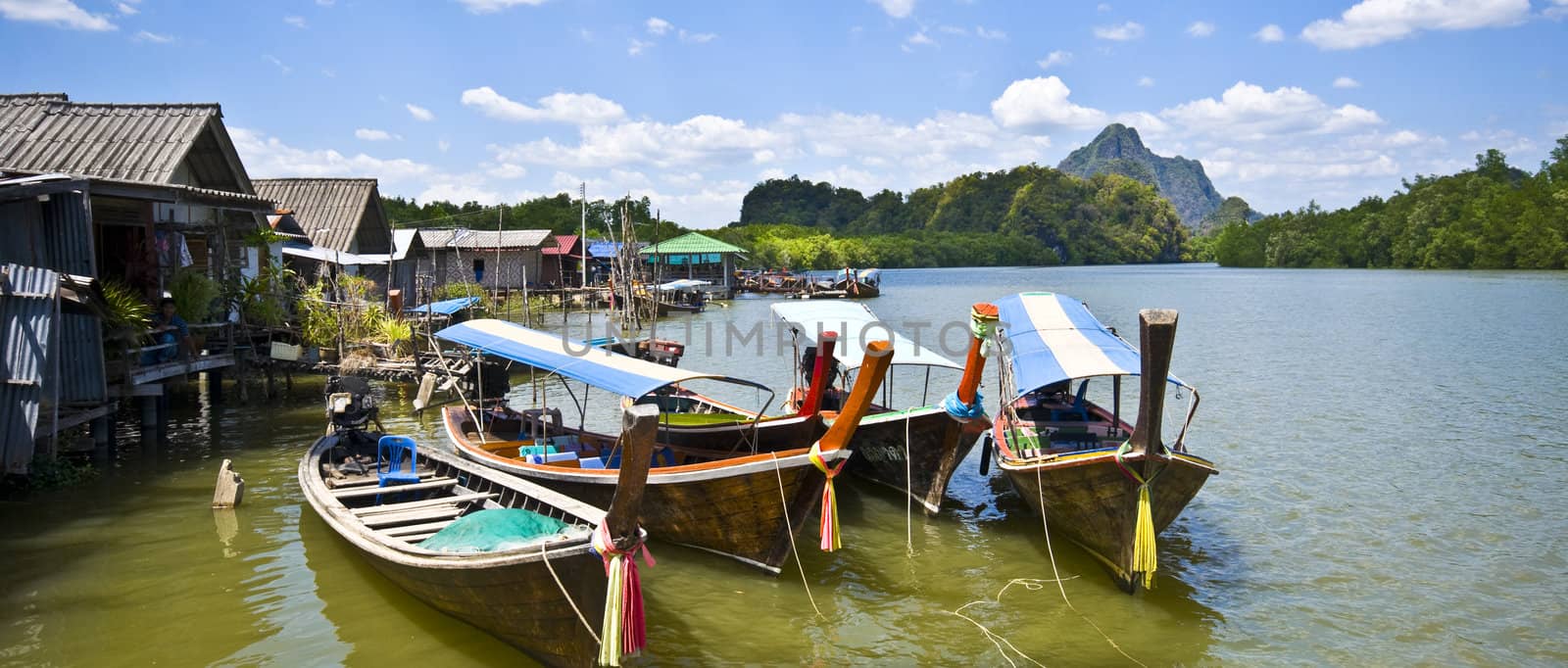 colorful longboats at a pier in the Phang Nga Bay