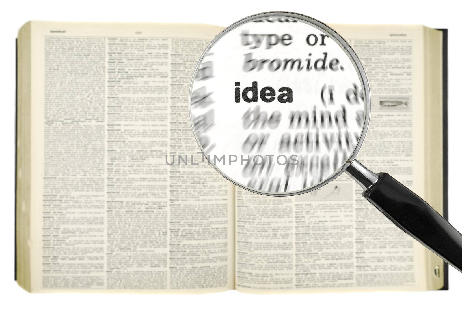 A magnifying glass on the word IDEA on a dictionary. Isolated on white.