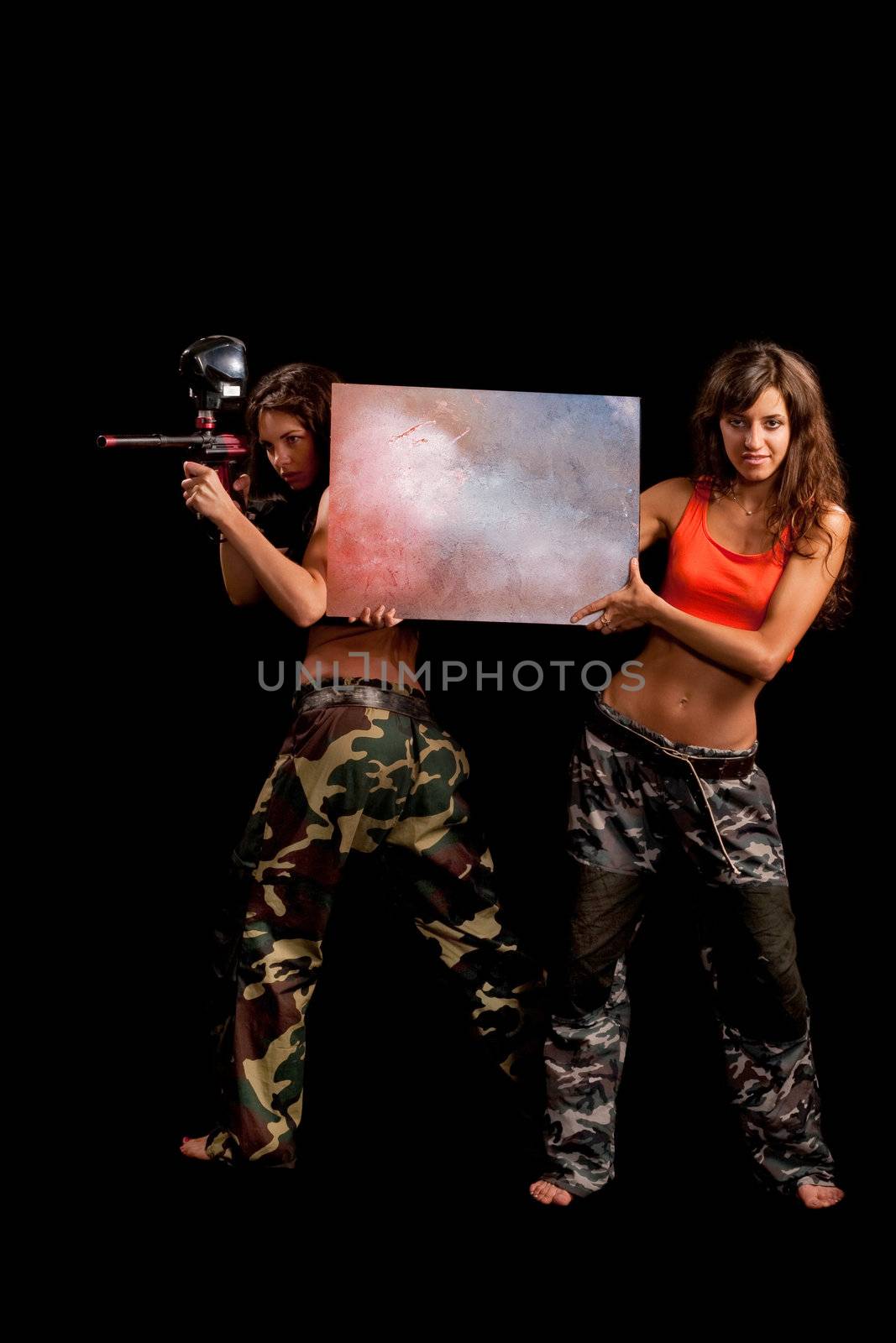Two girls posing for camera and one holds a table like she advertise something