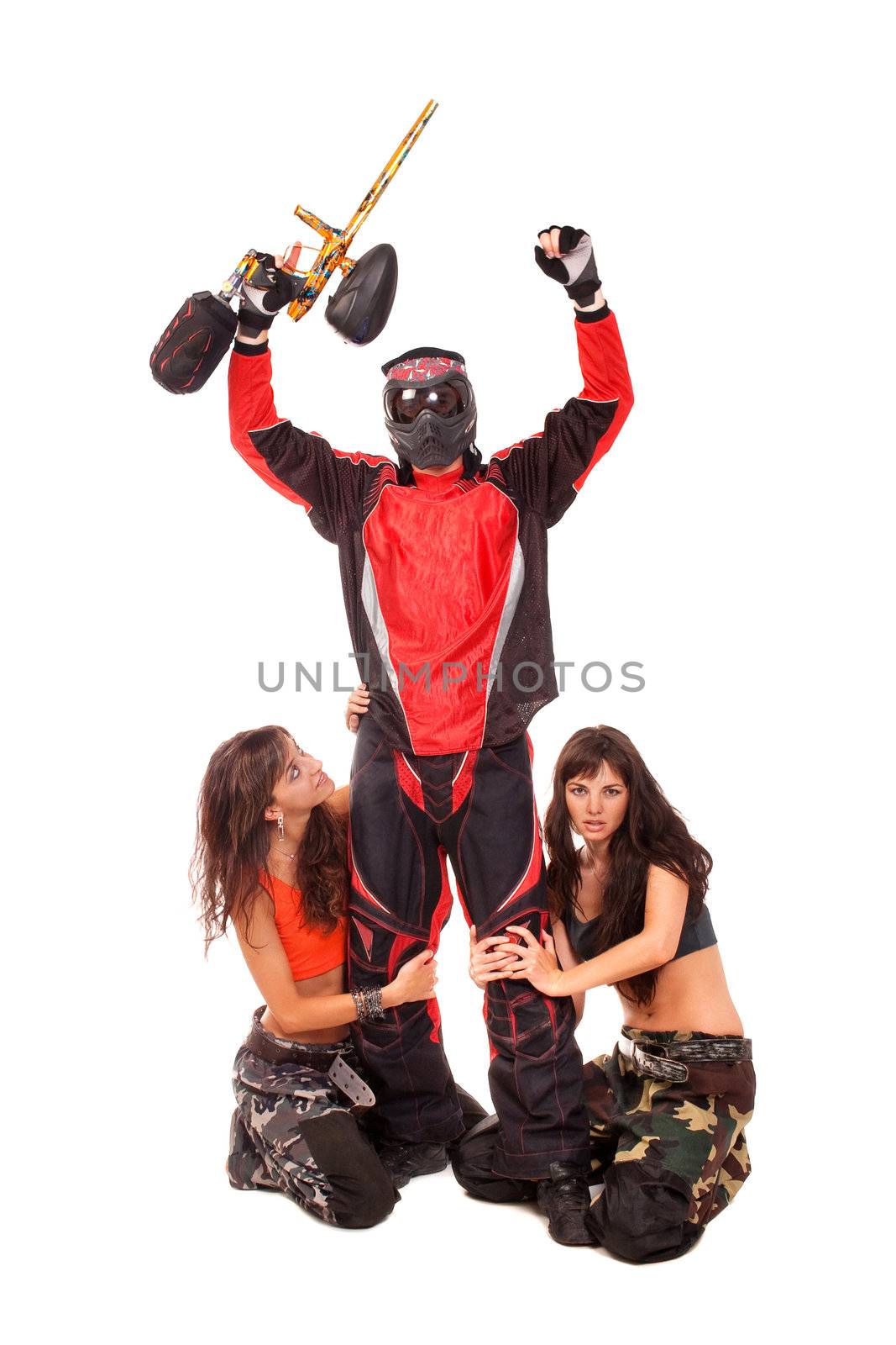 Paintball player with girls on a knees around him