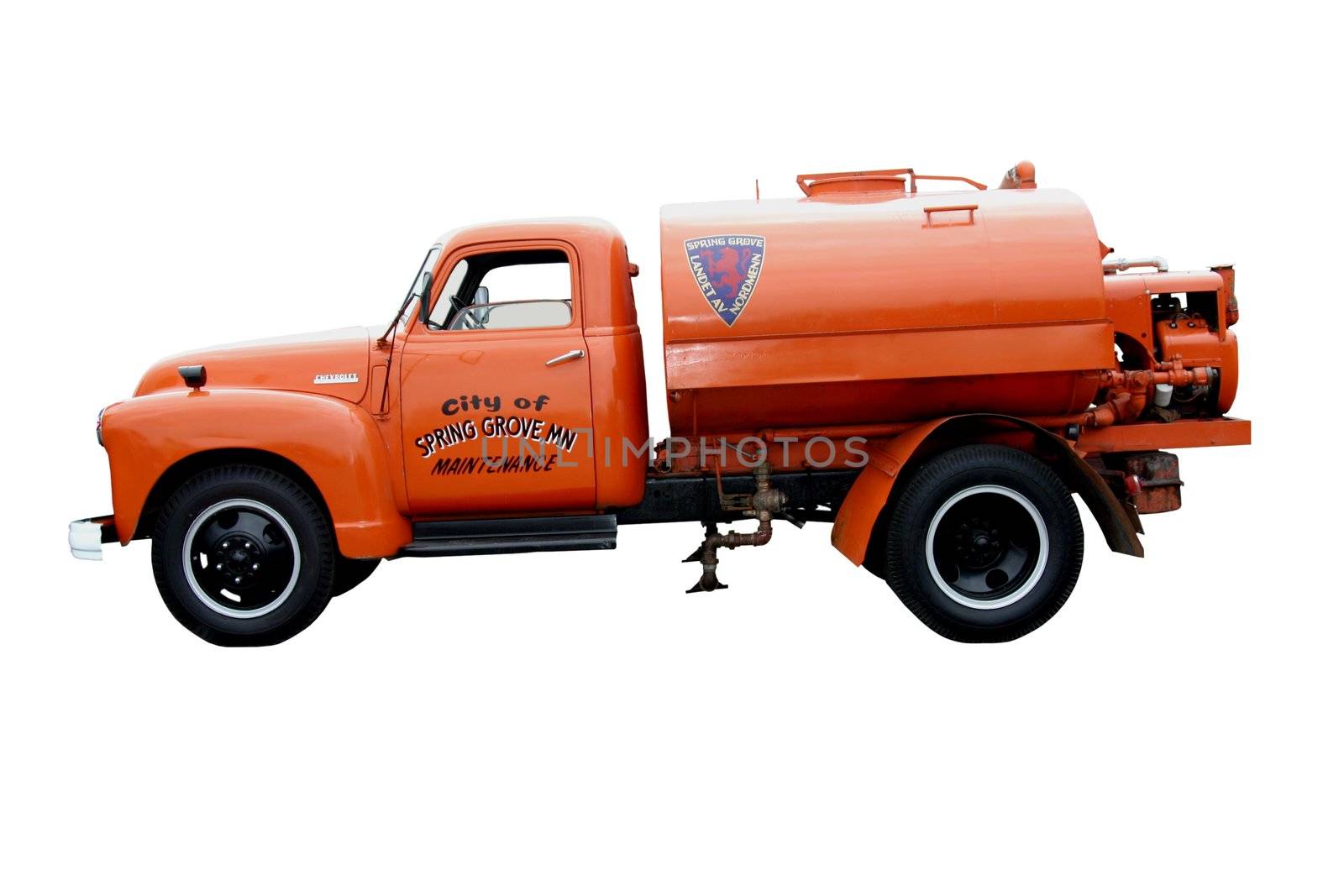 This is a picture on a late 1940s Chevrolet orange city Spring Grove, MN road maintenance tanker truck that is used for spraying oil down on dirt roads to keep the dust down. Taken at a classic truck show.