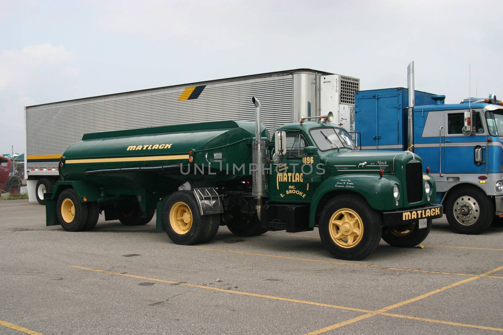 This is a dark green side view of a Matlack fuel tanker truck and trailer.