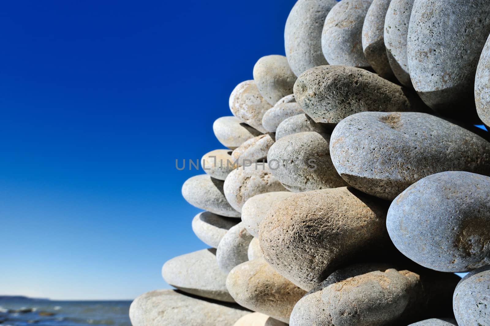 Some quantity cobblestones one on another on sea coast