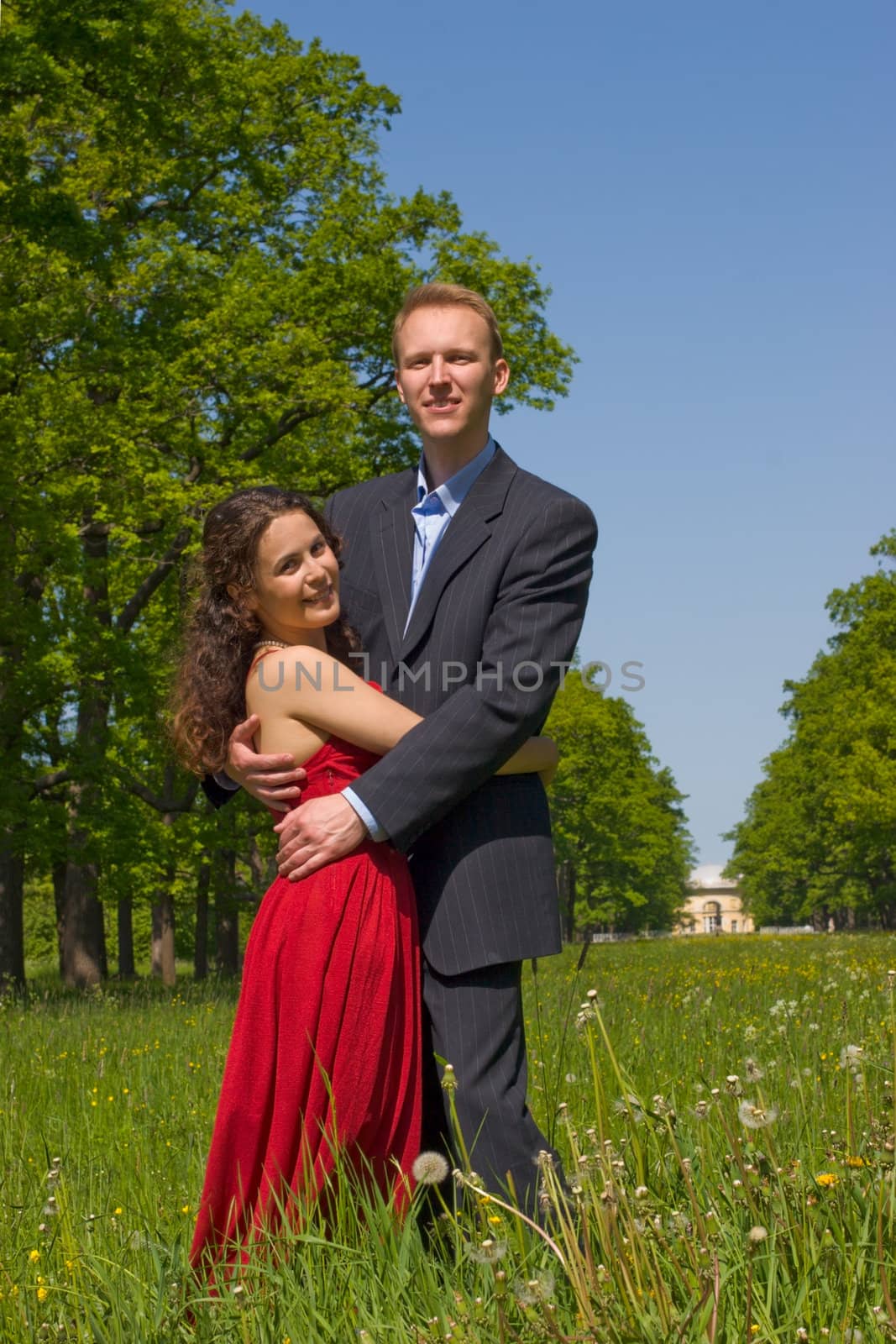 Happy young couple embracing in summer meadow