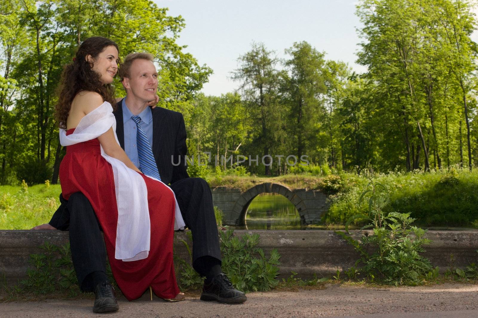 Happy young couple sitting  in park