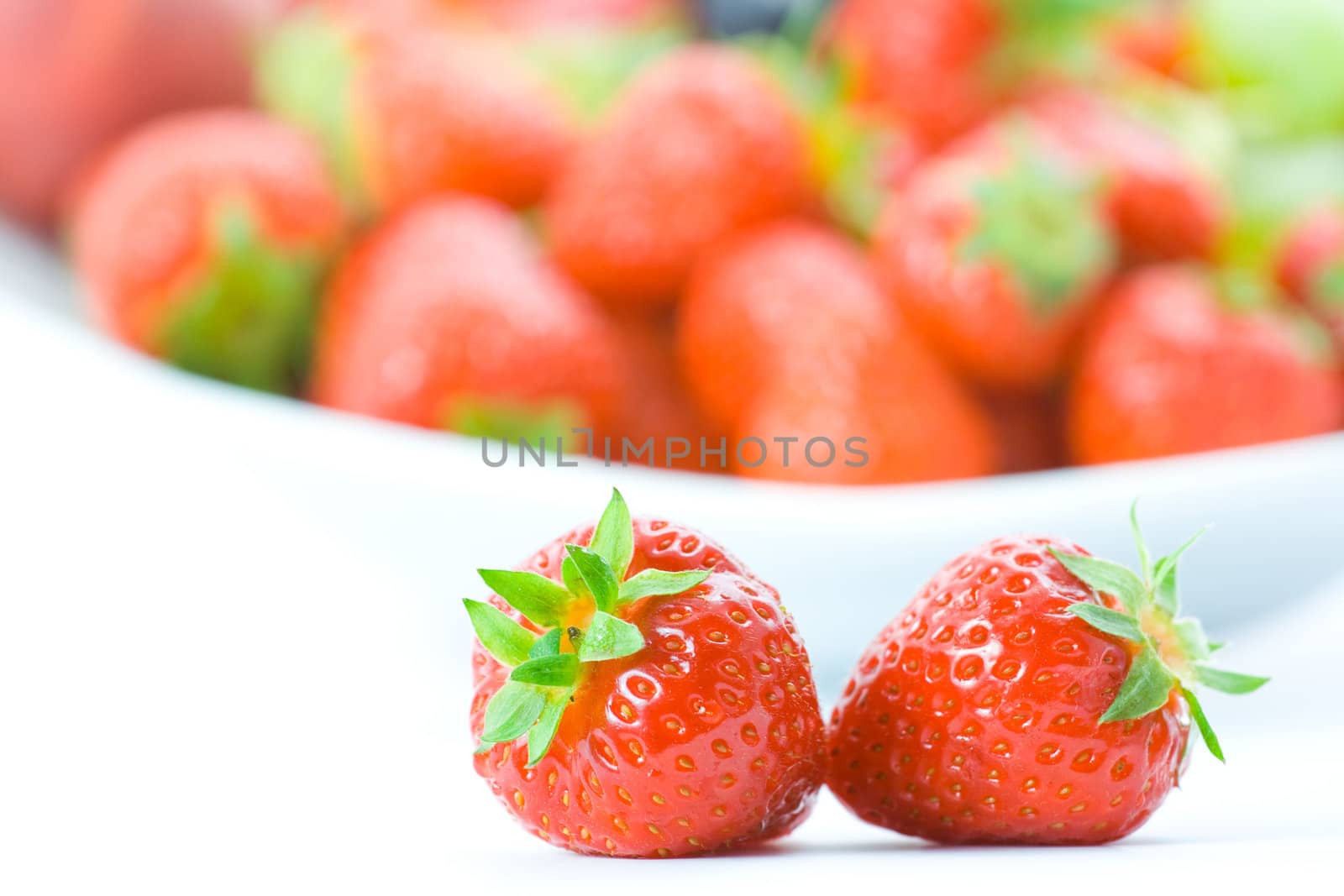 Delicious strawberries on white with shallow depth of field.