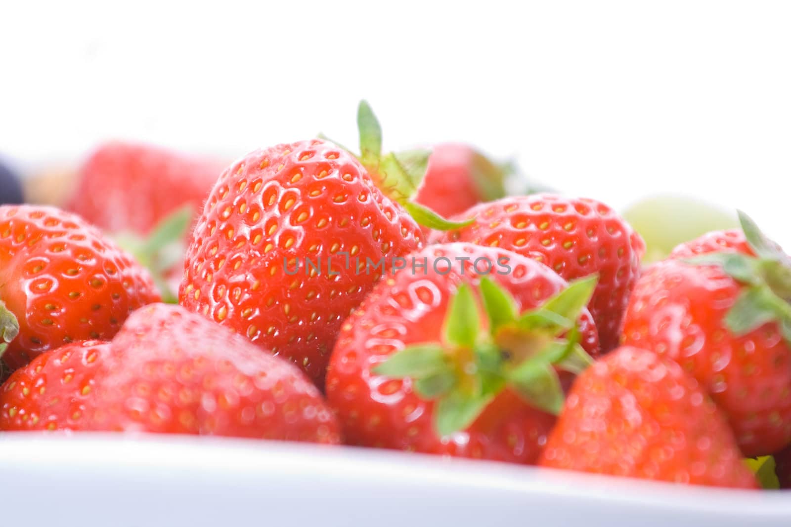 Delicious red strawberries on a plate with shallow depth of field.