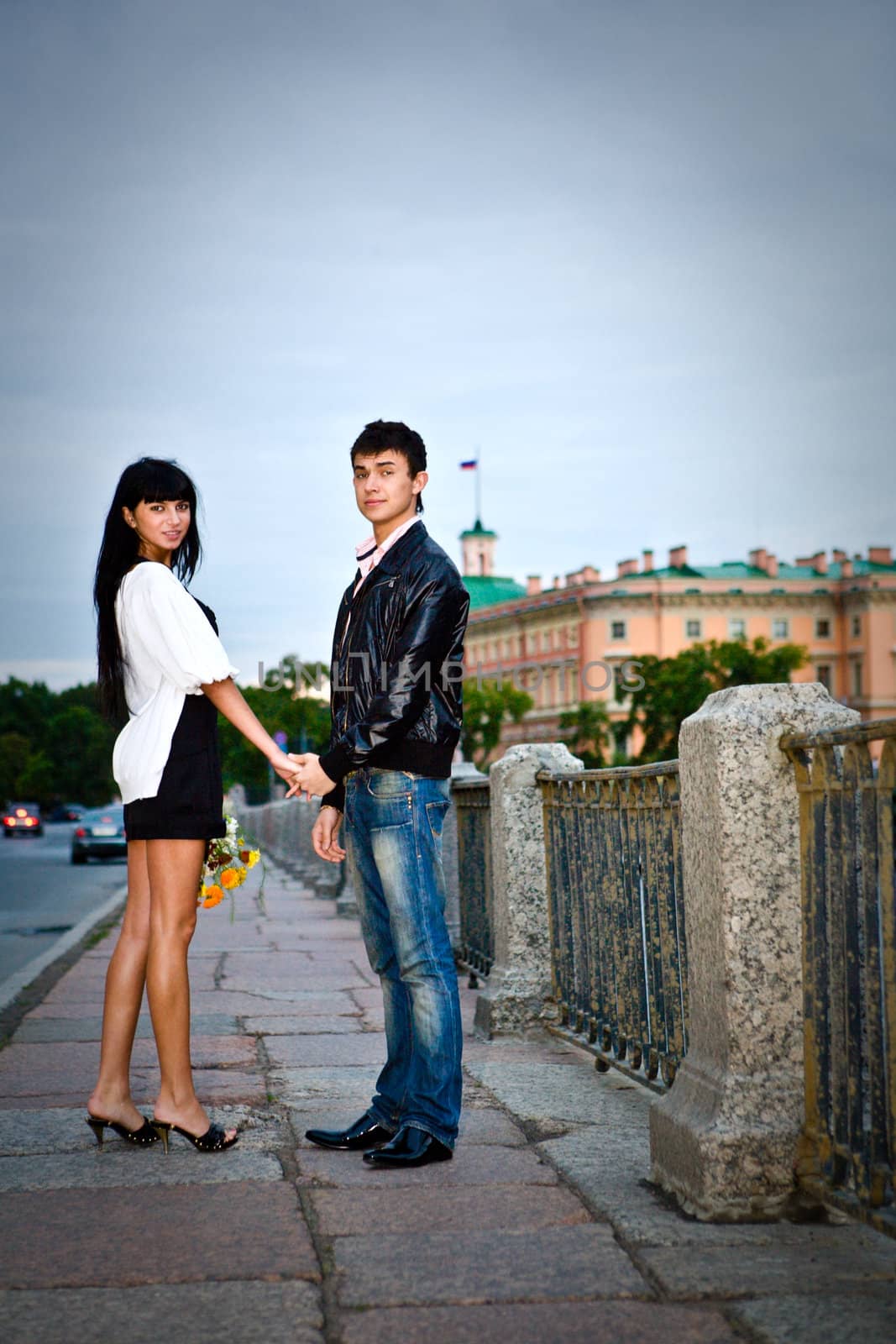 Happy young couple walking on city bridge