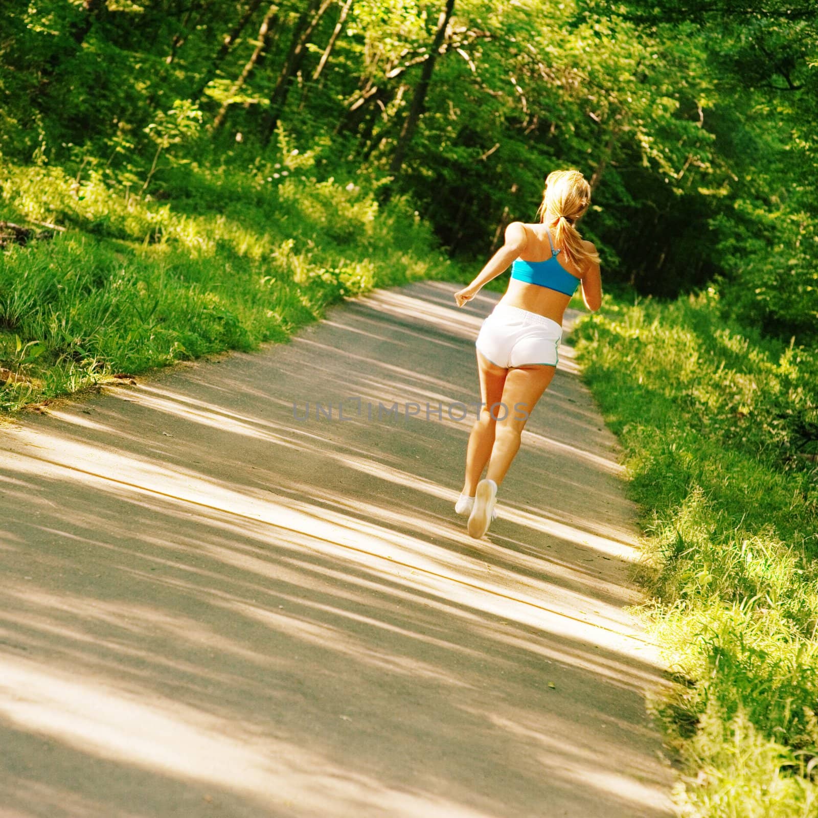 Young woman working out on a forest path.