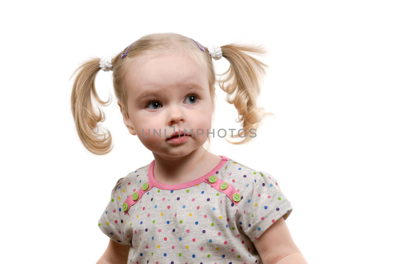 Closeup portrait of little girl with ponytails sitting on the floor