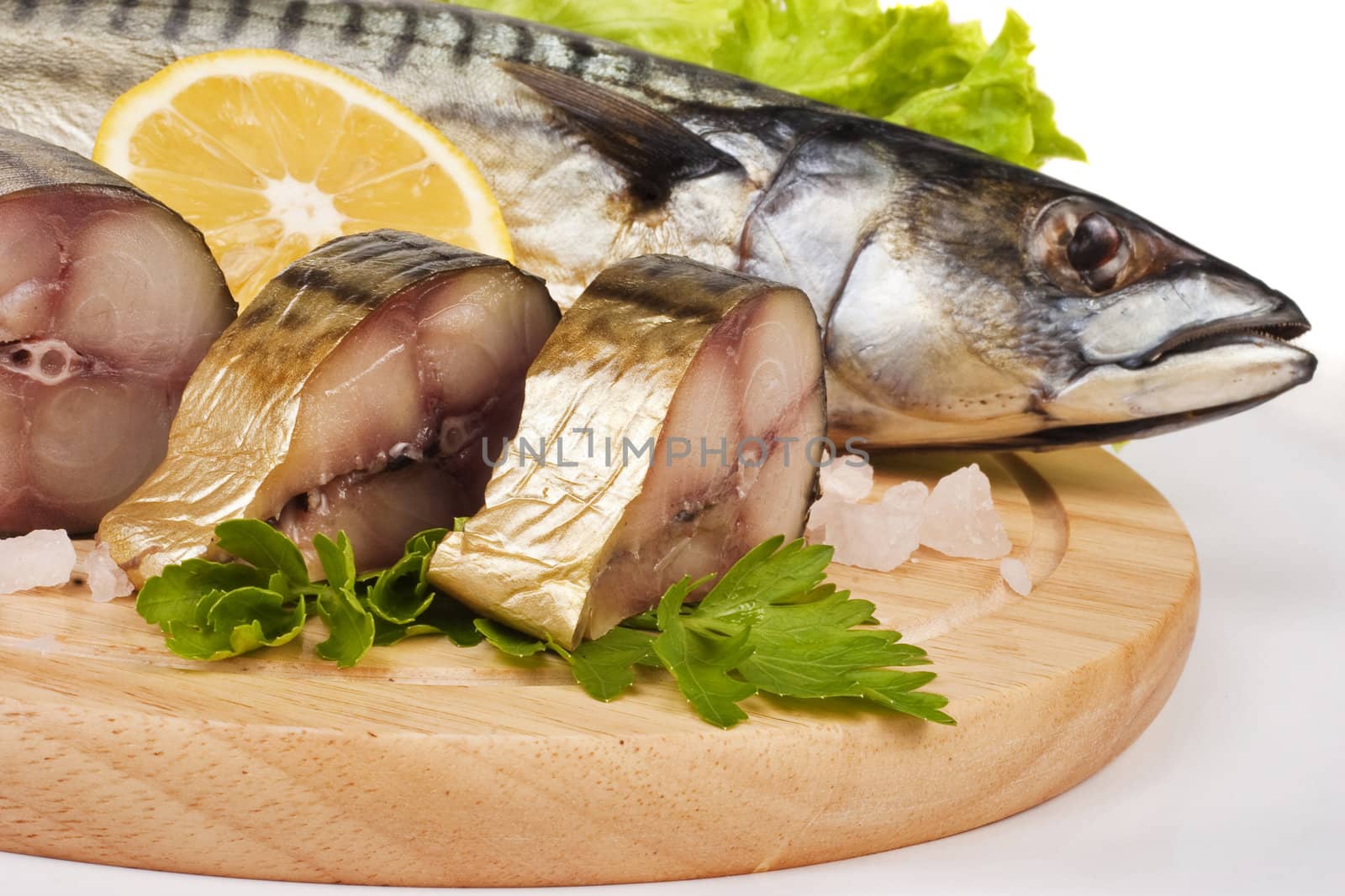 A composition with mackerel fish on wooden plate isolated on white