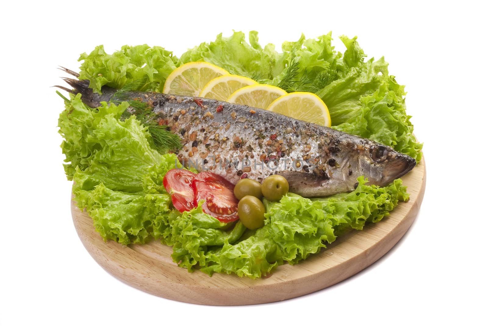 A composition with marinated herring fish and vegetables on wooden plate isolated on white