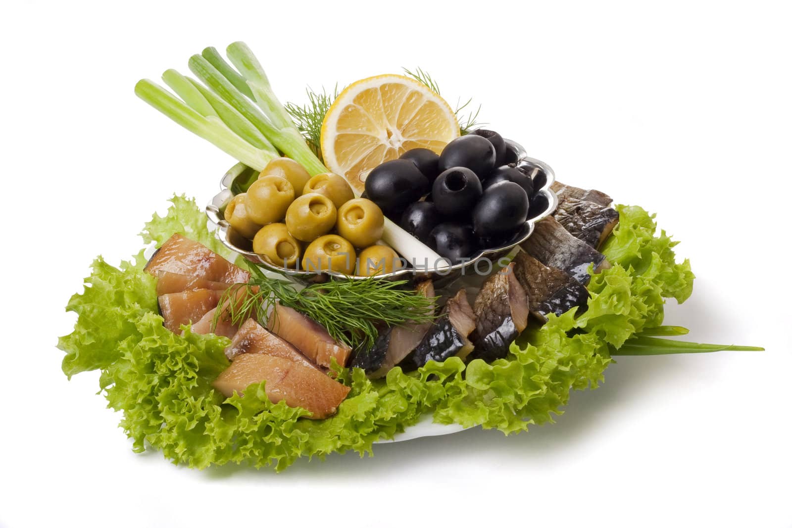 A composition with smoked herring pieces with vegetables on plate isolated on white