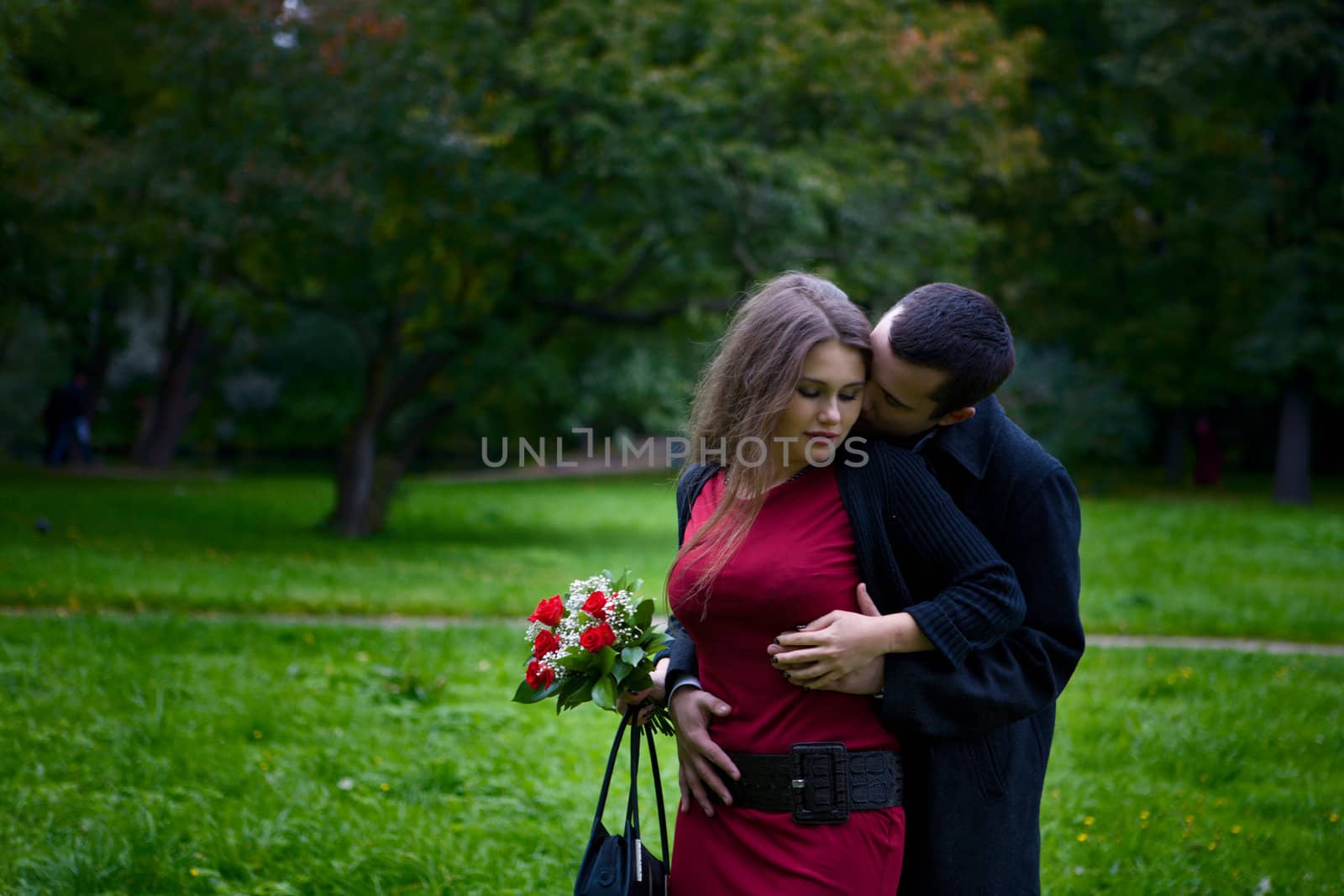 Two young lovers enjoying each other in park