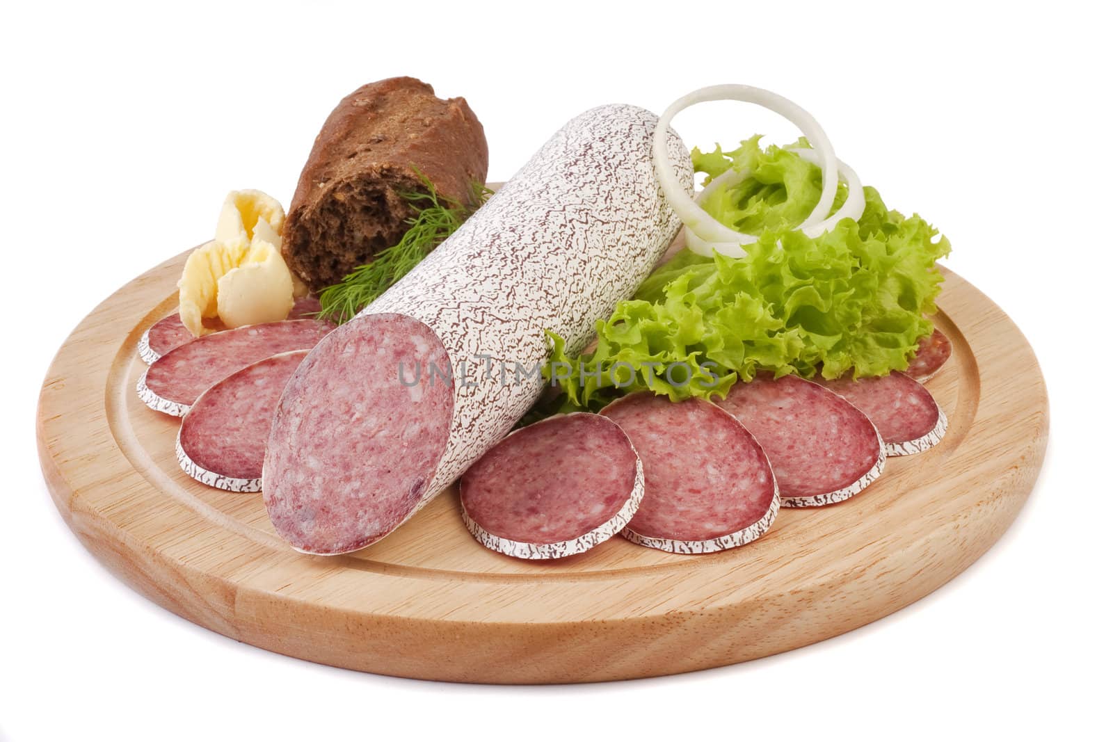 Sliced sausage with rye bread, butter and vegetables on a wooden plate isolated