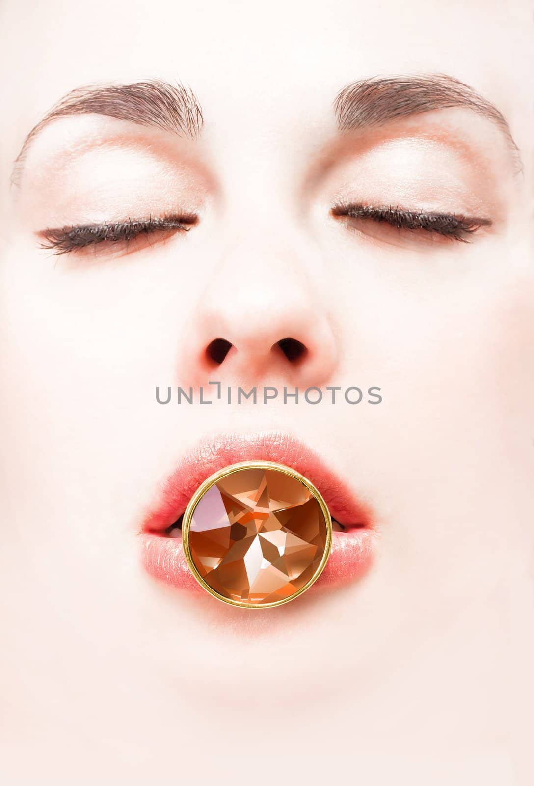 Girl�s face holding gem with lips