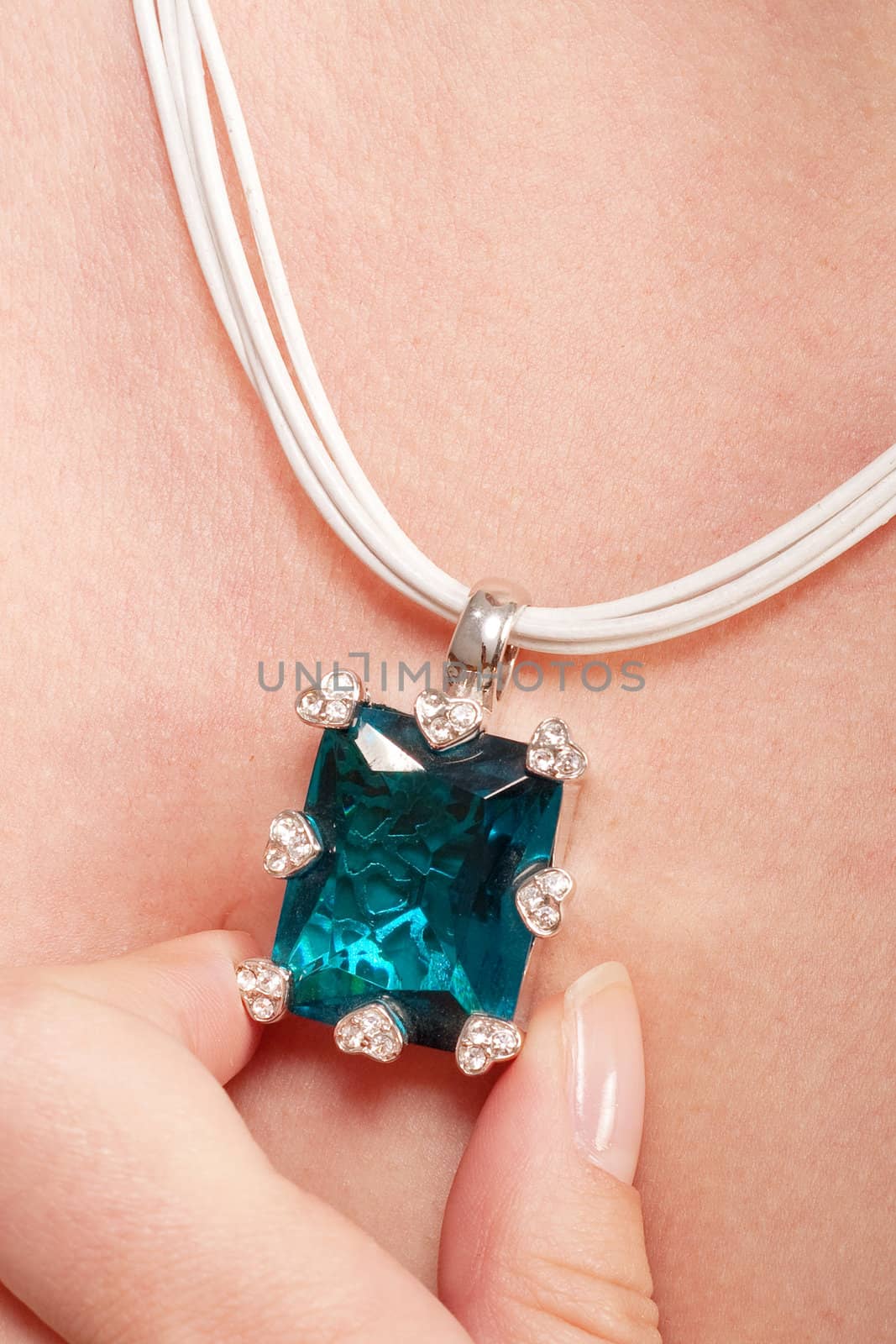 Necklace with blue gem keeping up with fingers