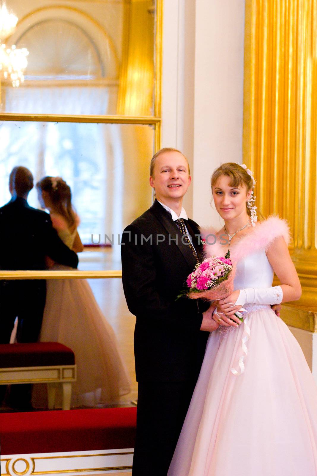 Bride and groom together indoors looking at you
