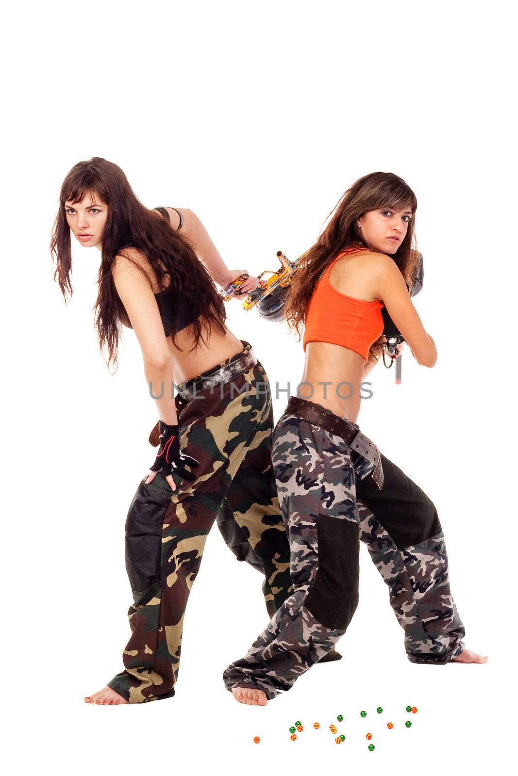 Two young beautiful girls posing like playing paintball