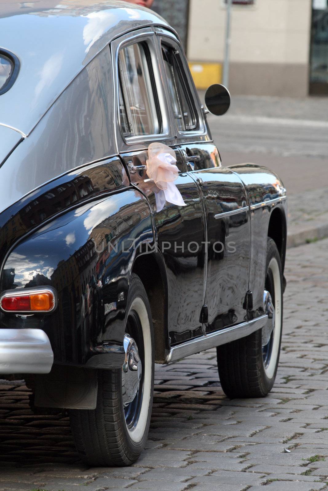 Old retro-style decorated car to pick up Bride and Groom