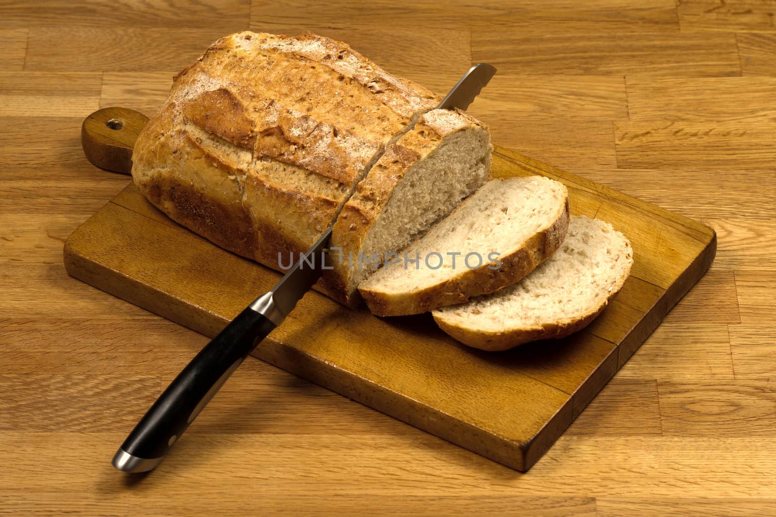Wooden cutting board with white bread and knife by lavsen