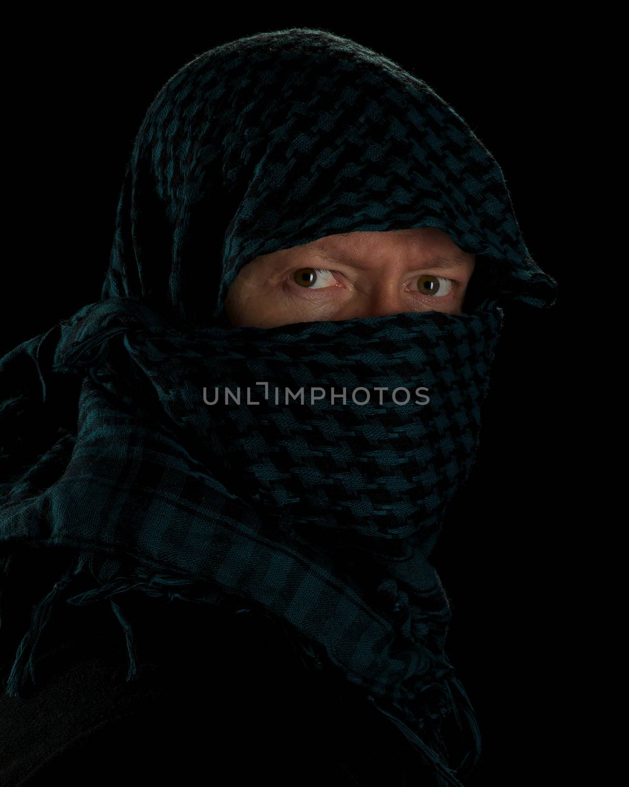 man wearing islamic headgear against a black background