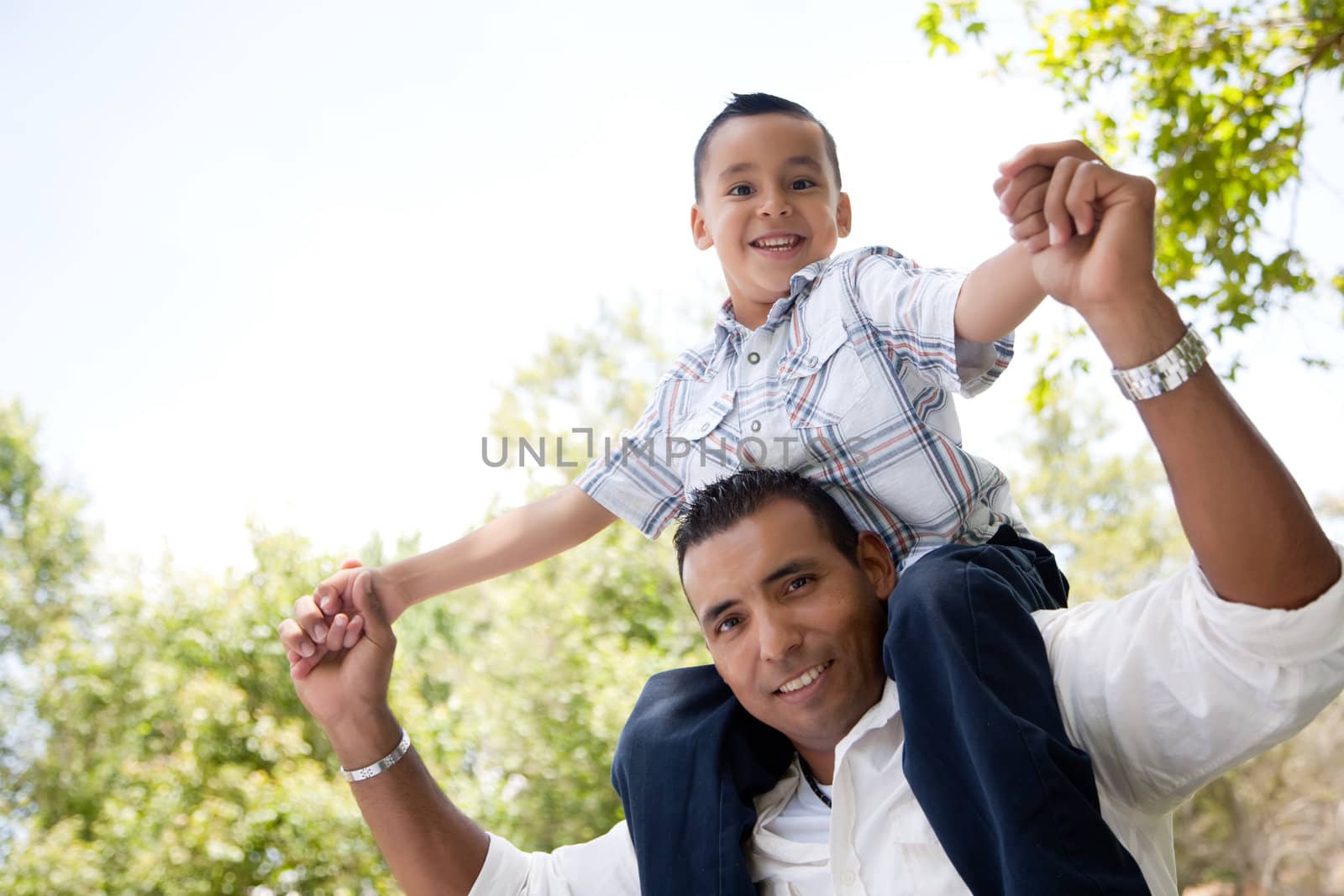 Hispanic Father and Son Having Fun in the Park by Feverpitched