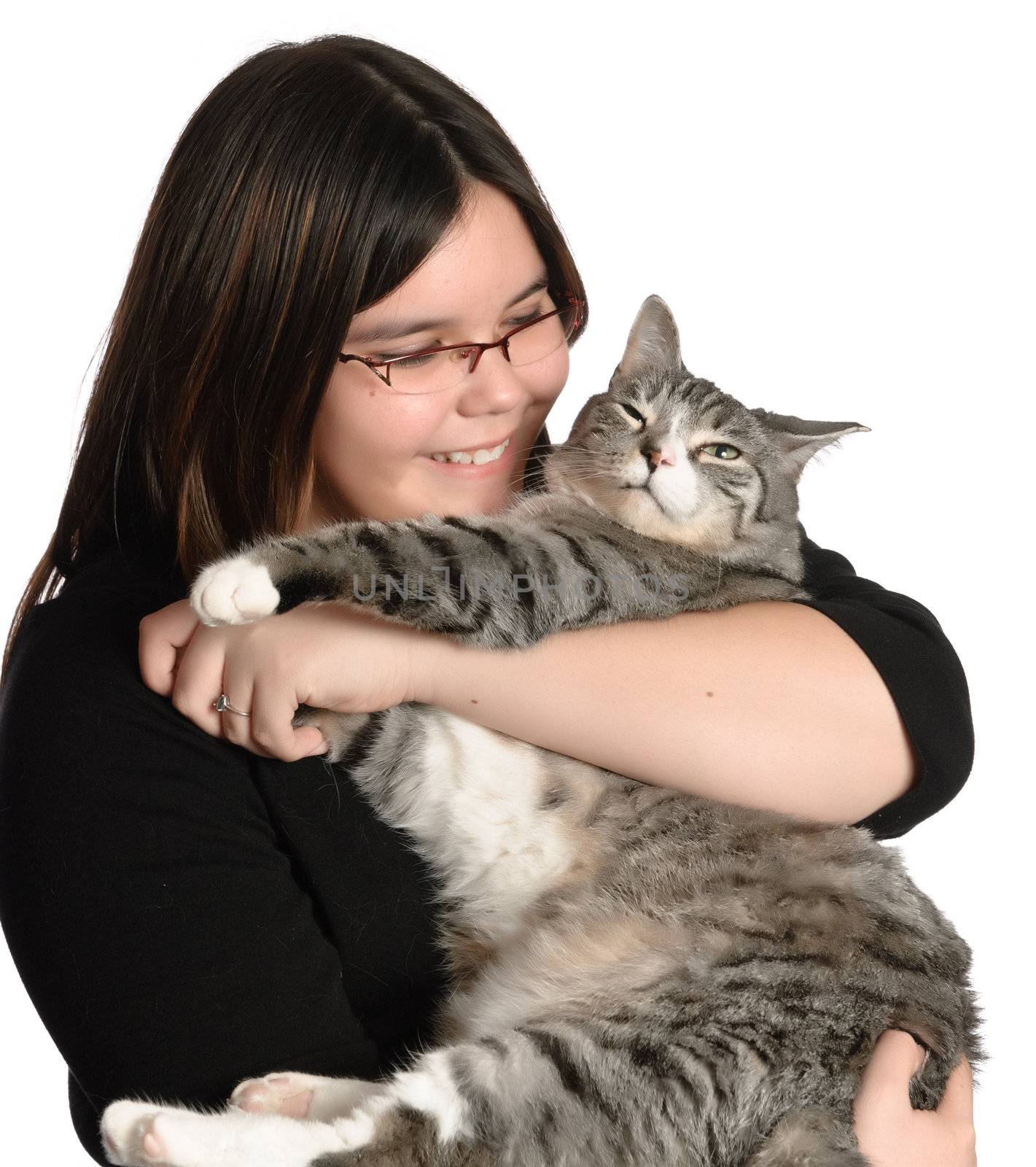 A young teen girl is loving and holding her pet cat, isolated against a white background.