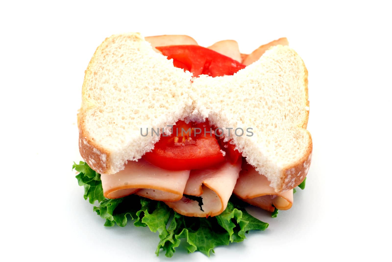 Low-carb diet concept with skinny bread slices on a turkey sandwich isolated over a white background