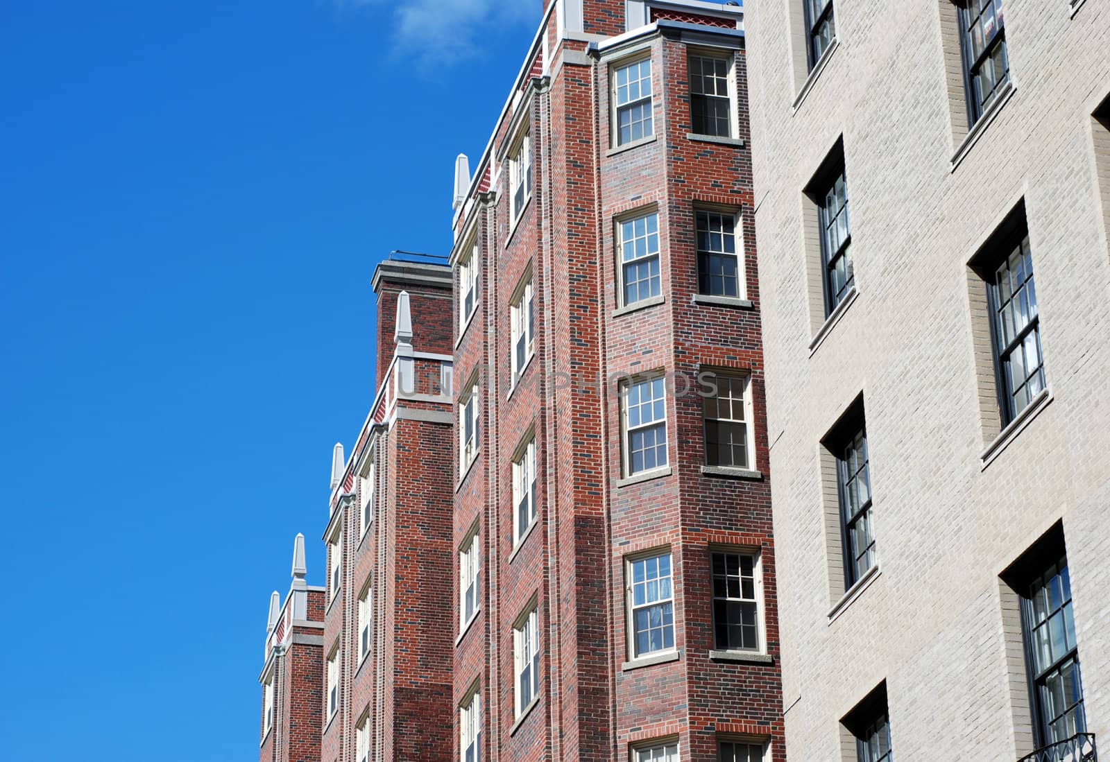 urban brick apartment buildings from below with blue sky