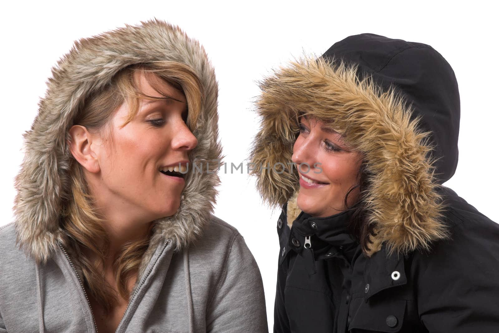 Two sisters wearing a winter downjacket and looking at eachother