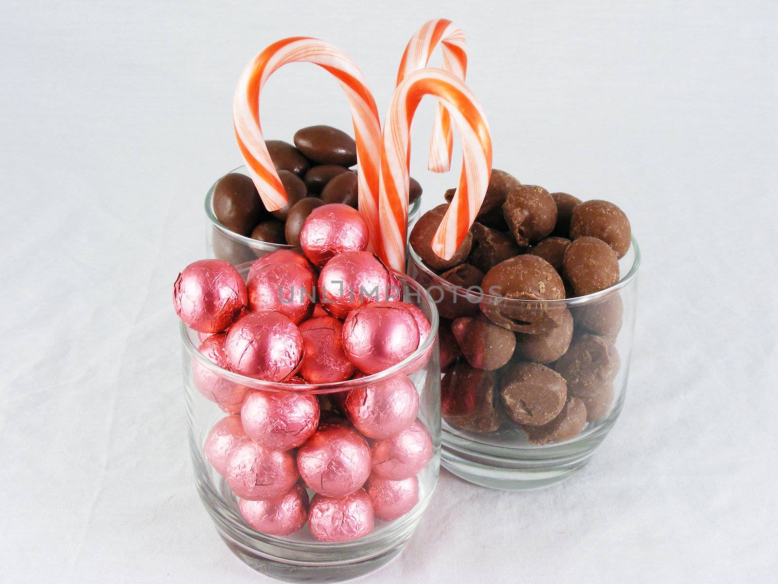 Chocolate covered almonds and peanuts, foil wrapped chocolate, and candy canes.