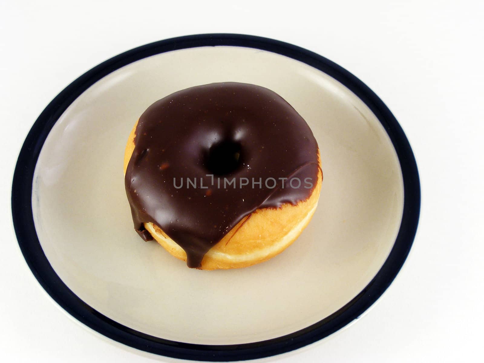 A chocolate iced donut on a plate against a white background.