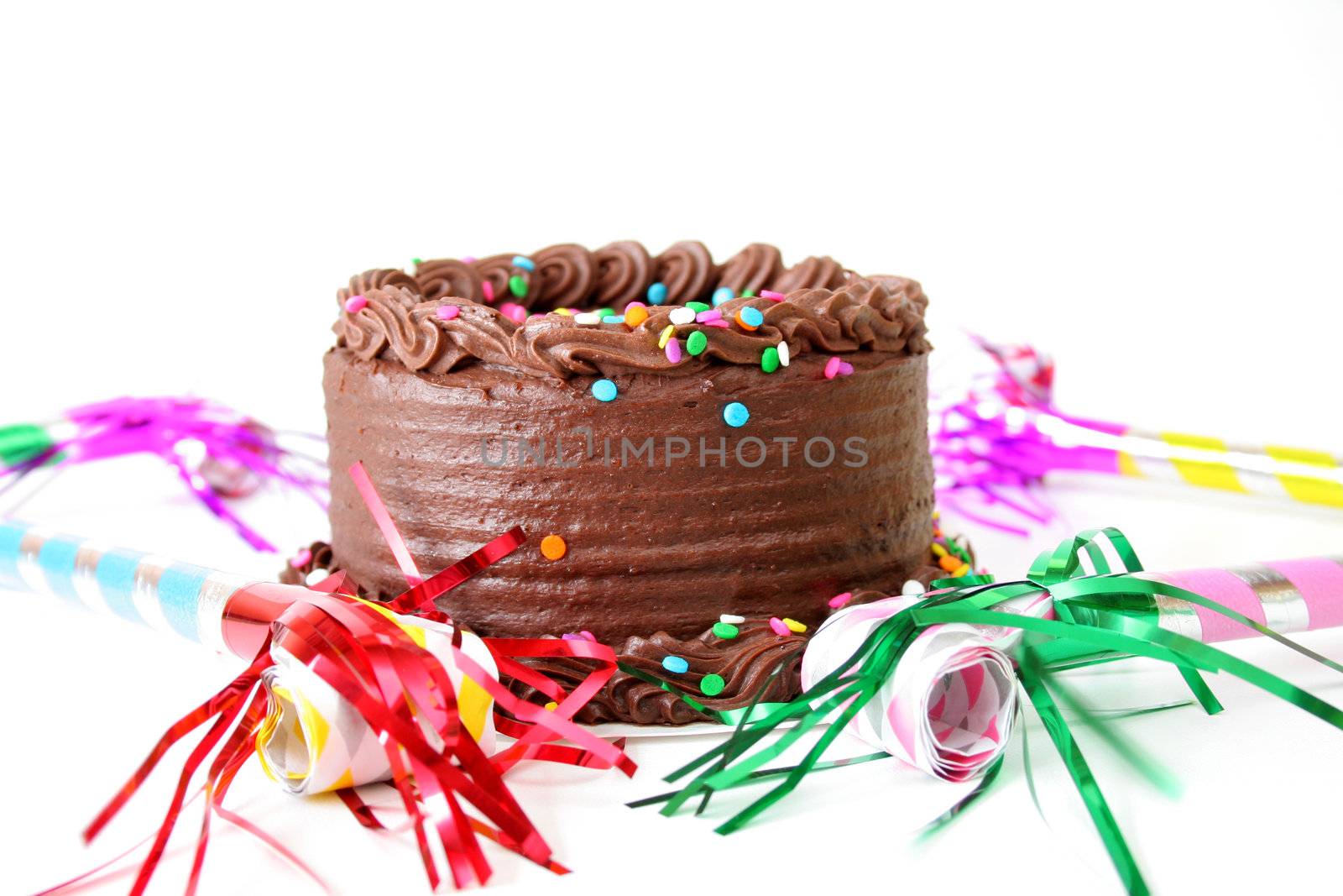 Chocolate birthday cake with sprinkles and noise makers all isolated on a white background