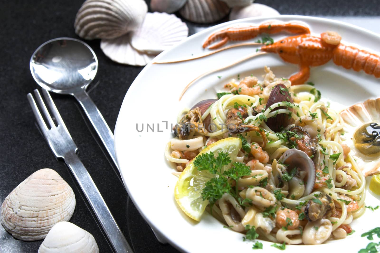 Delicious seafood dish with special fork and spoon to eat spaghetti