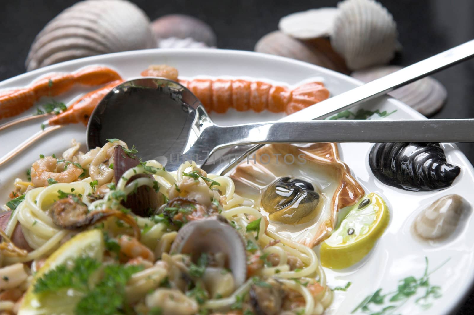 Seafood pasta dish served on a colorfull plate with shells, mussels and shrimps
