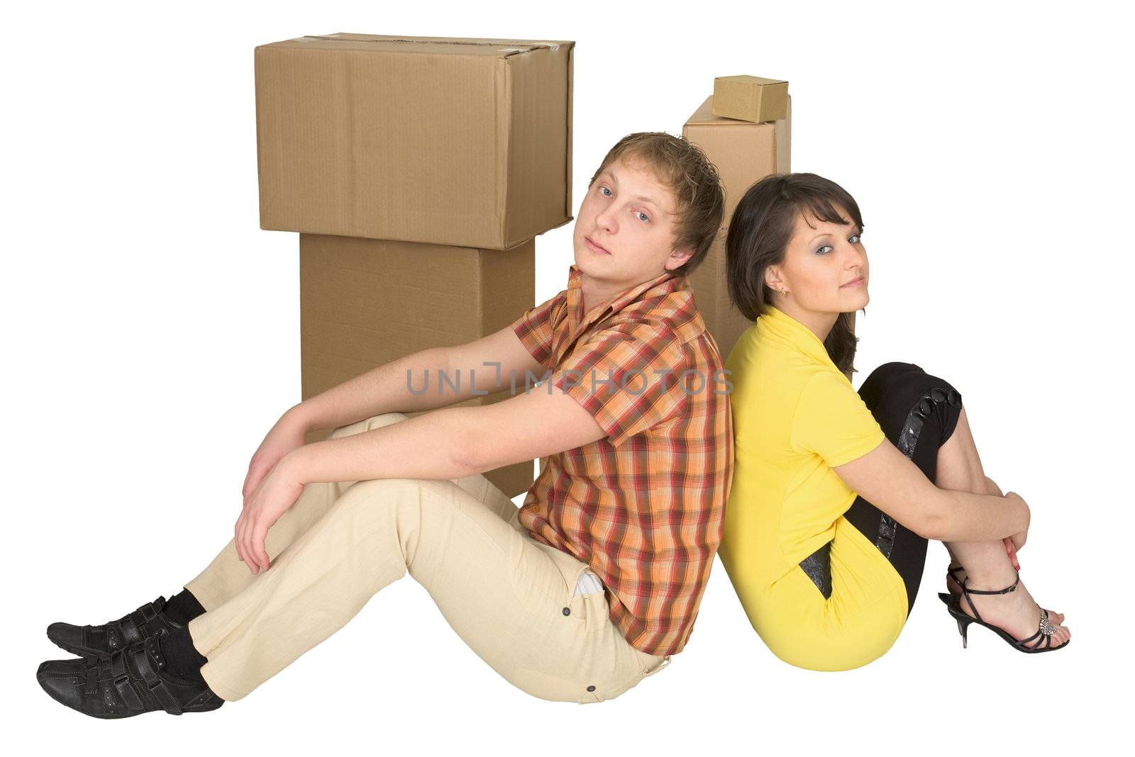 Young guy and the girl sit near boxes