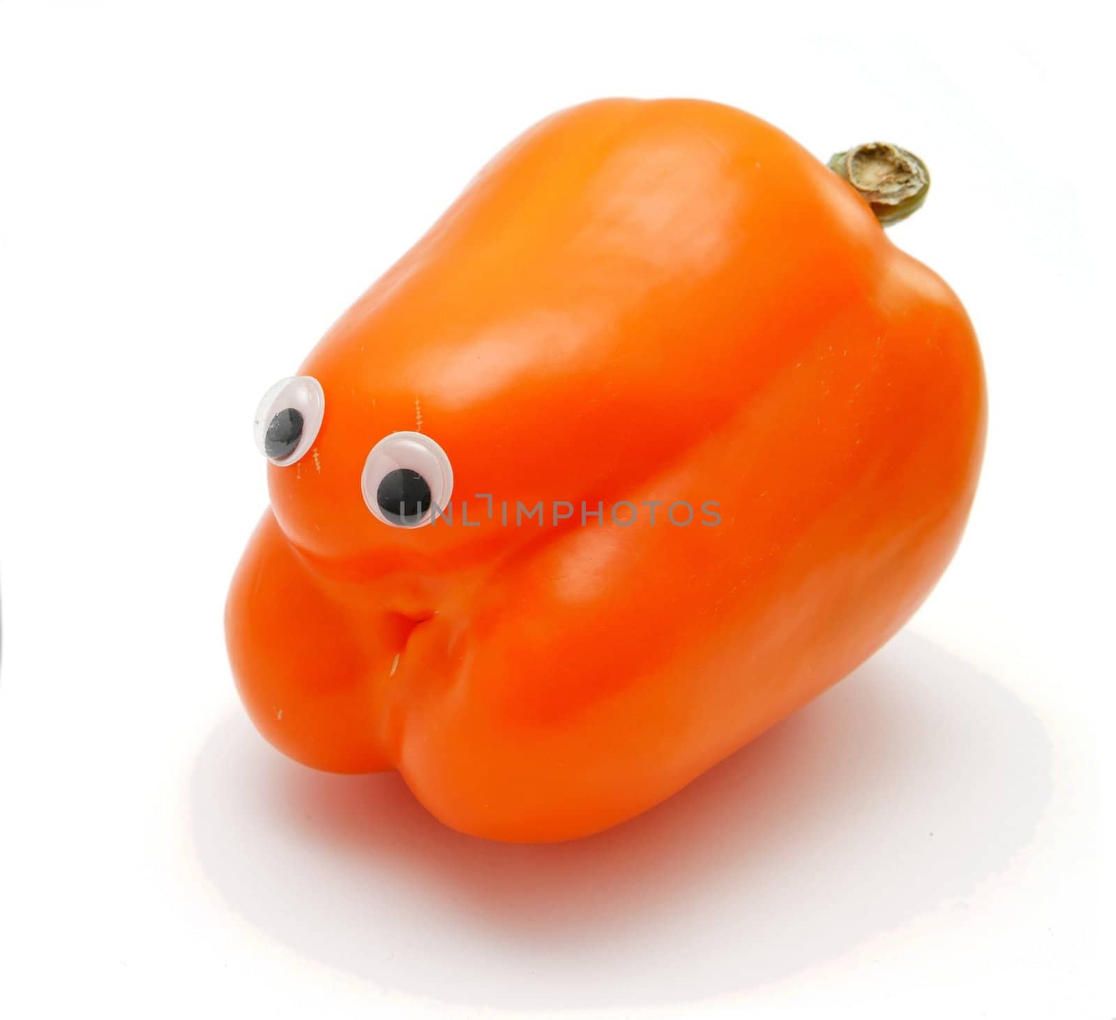 Sweet orange bell pepper with eyes on white background