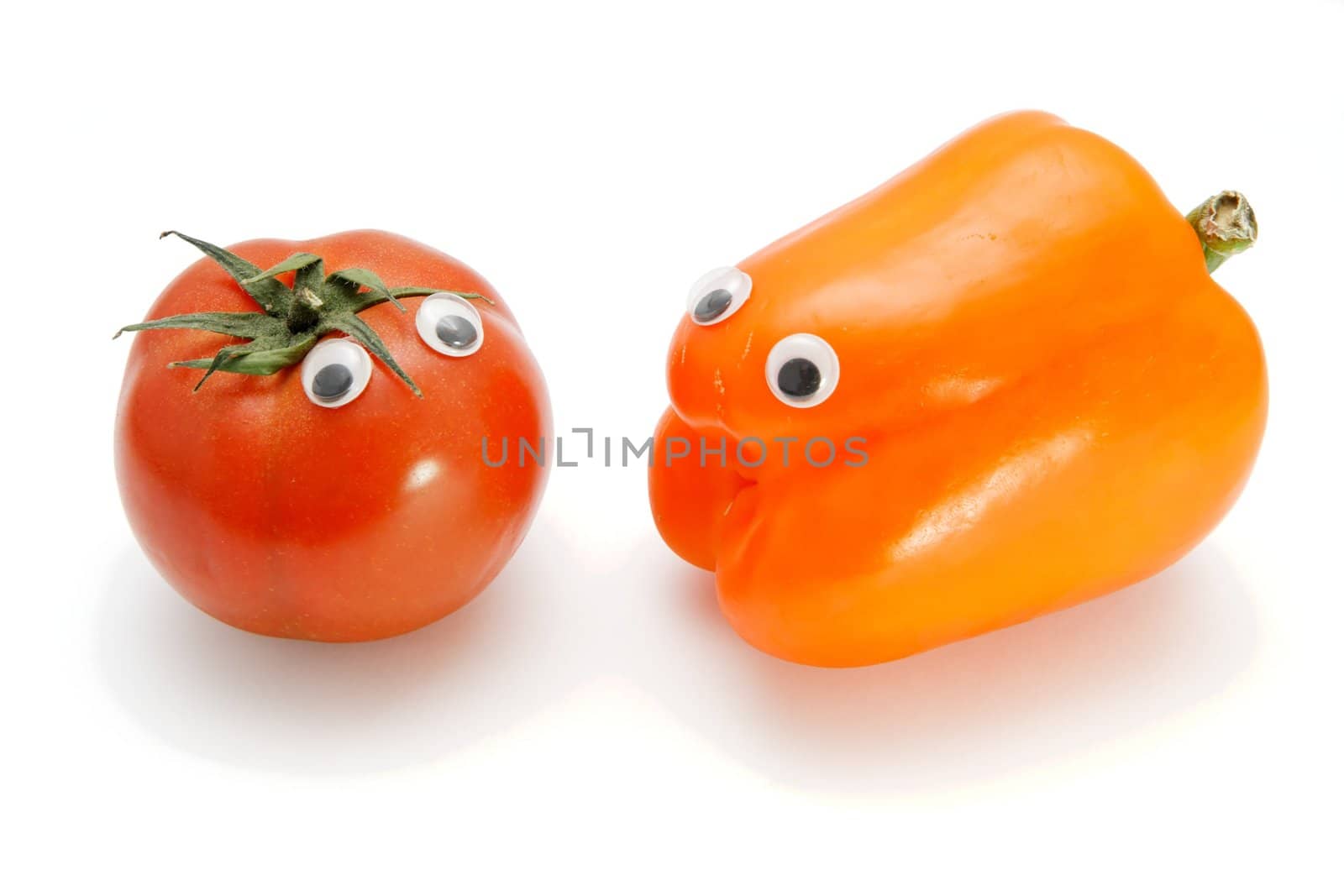 Red tomato and orange bellpepper with eyes on white background