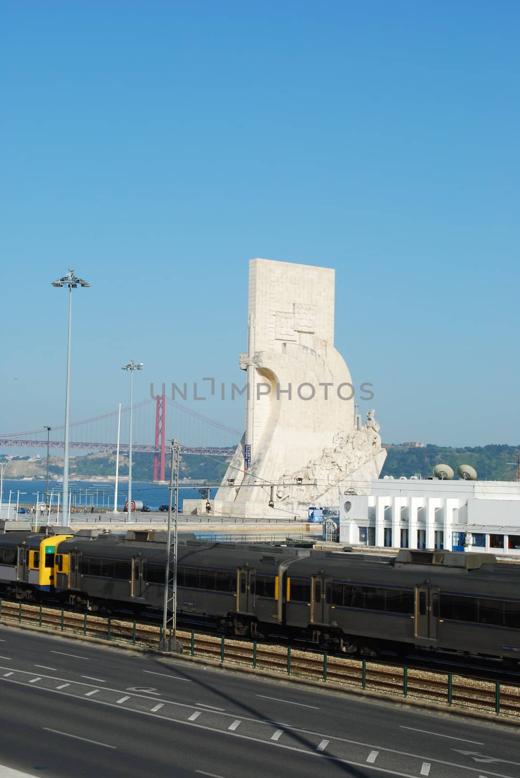 photo of a cityscape in Lisbon regarding the monumet of discoveries and April 25th bridge