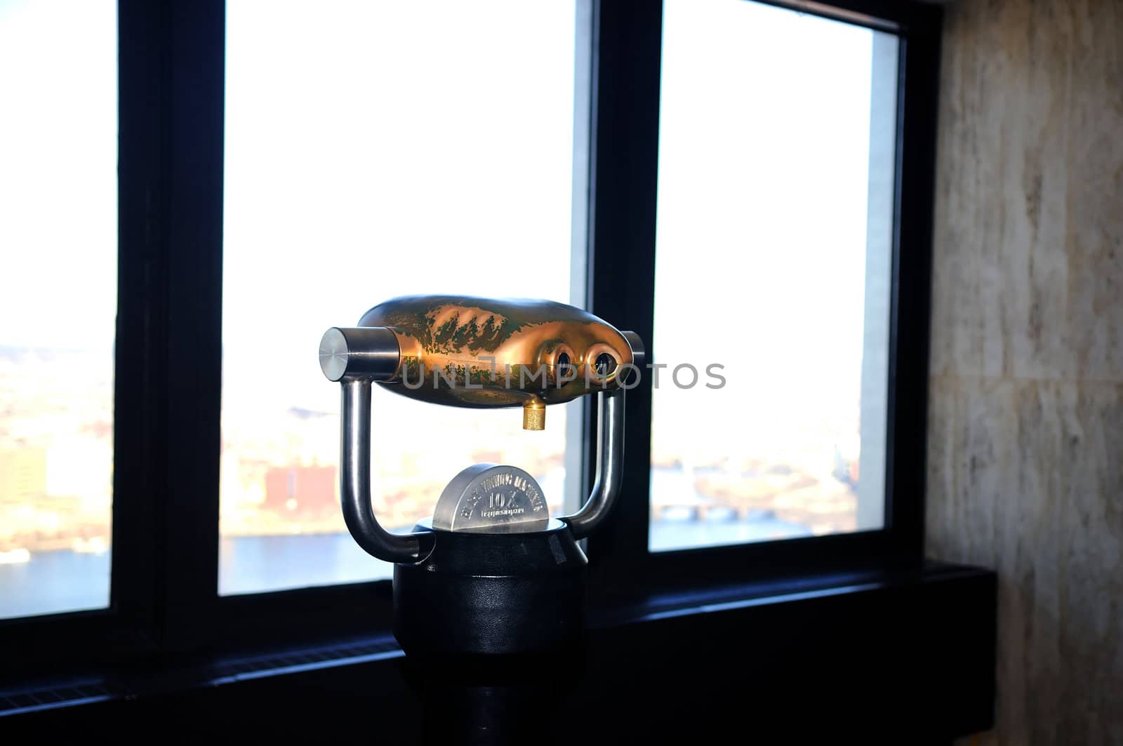 A coin operated binocular on the top of a tall building