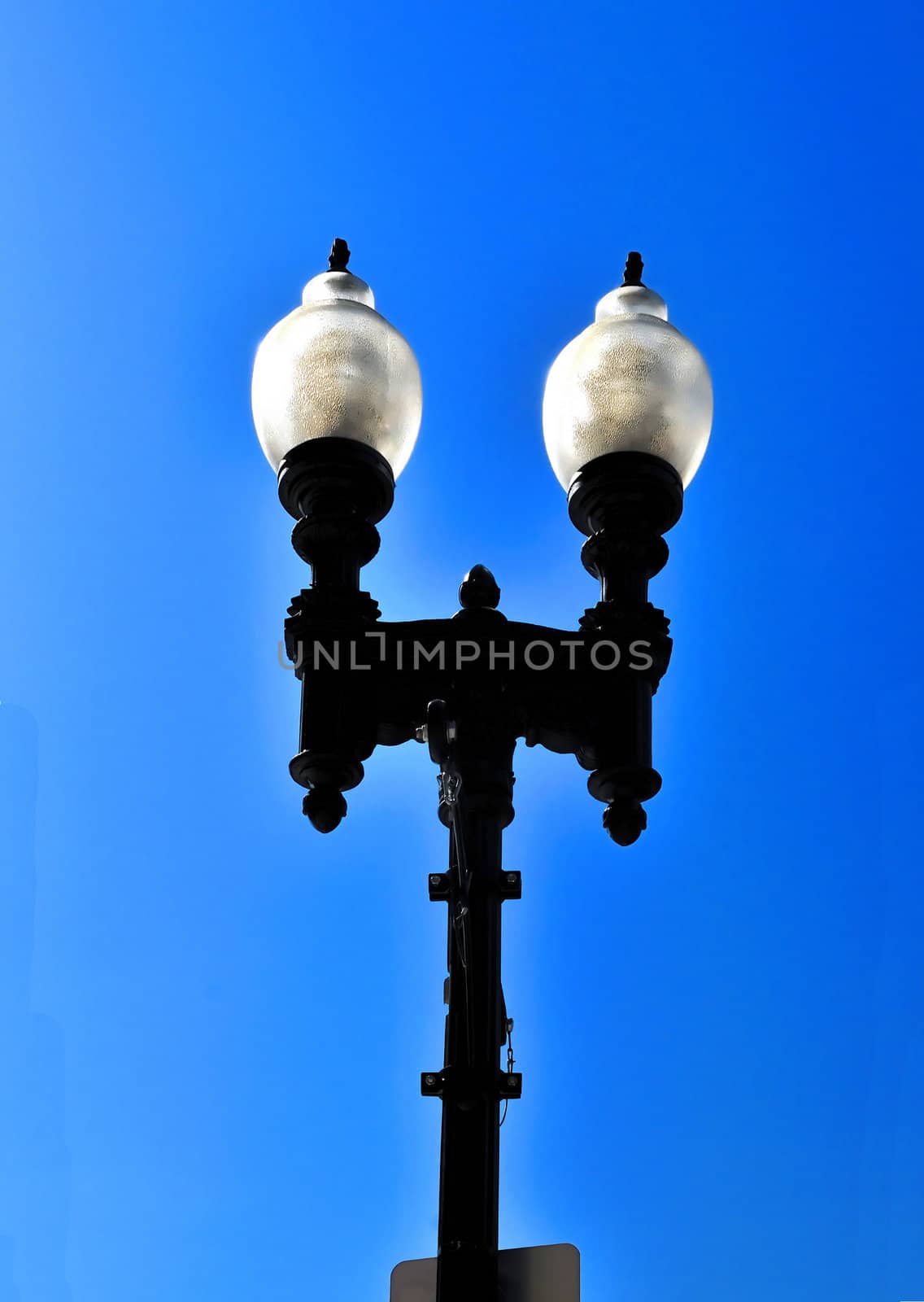 A streetlight isolated against a bright blue sky