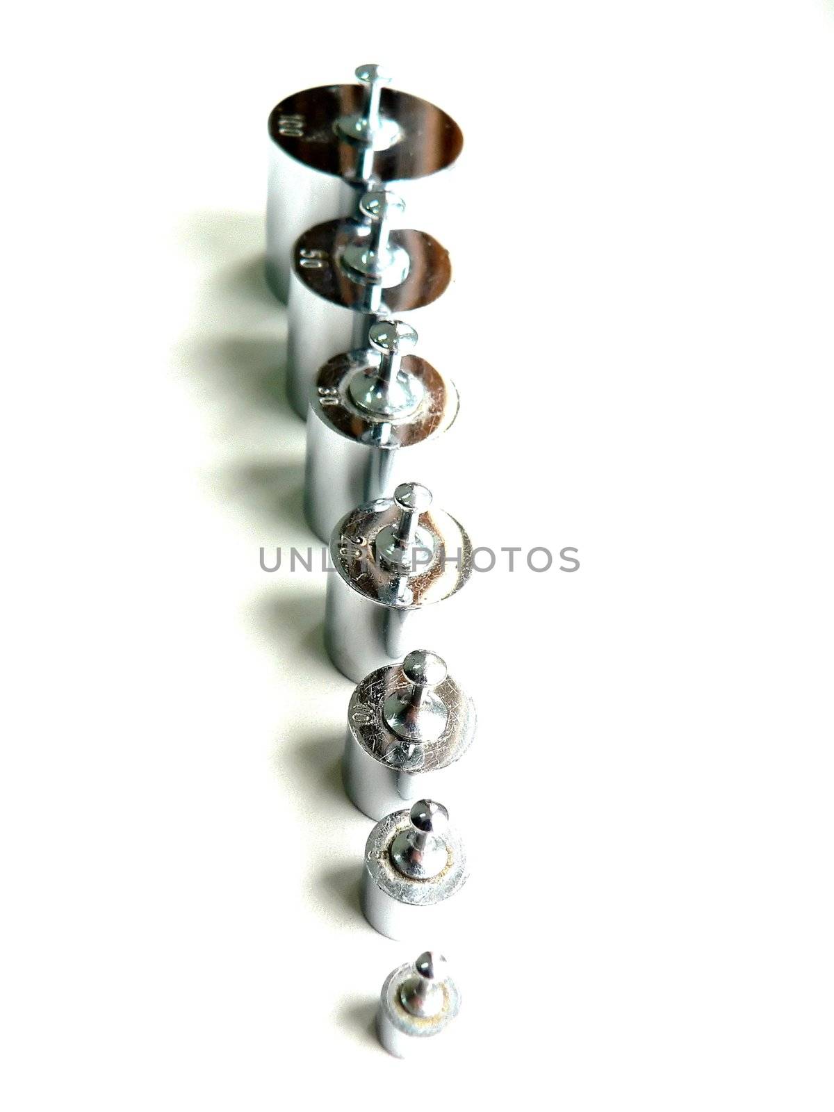 different sizes of small  weights lined up 