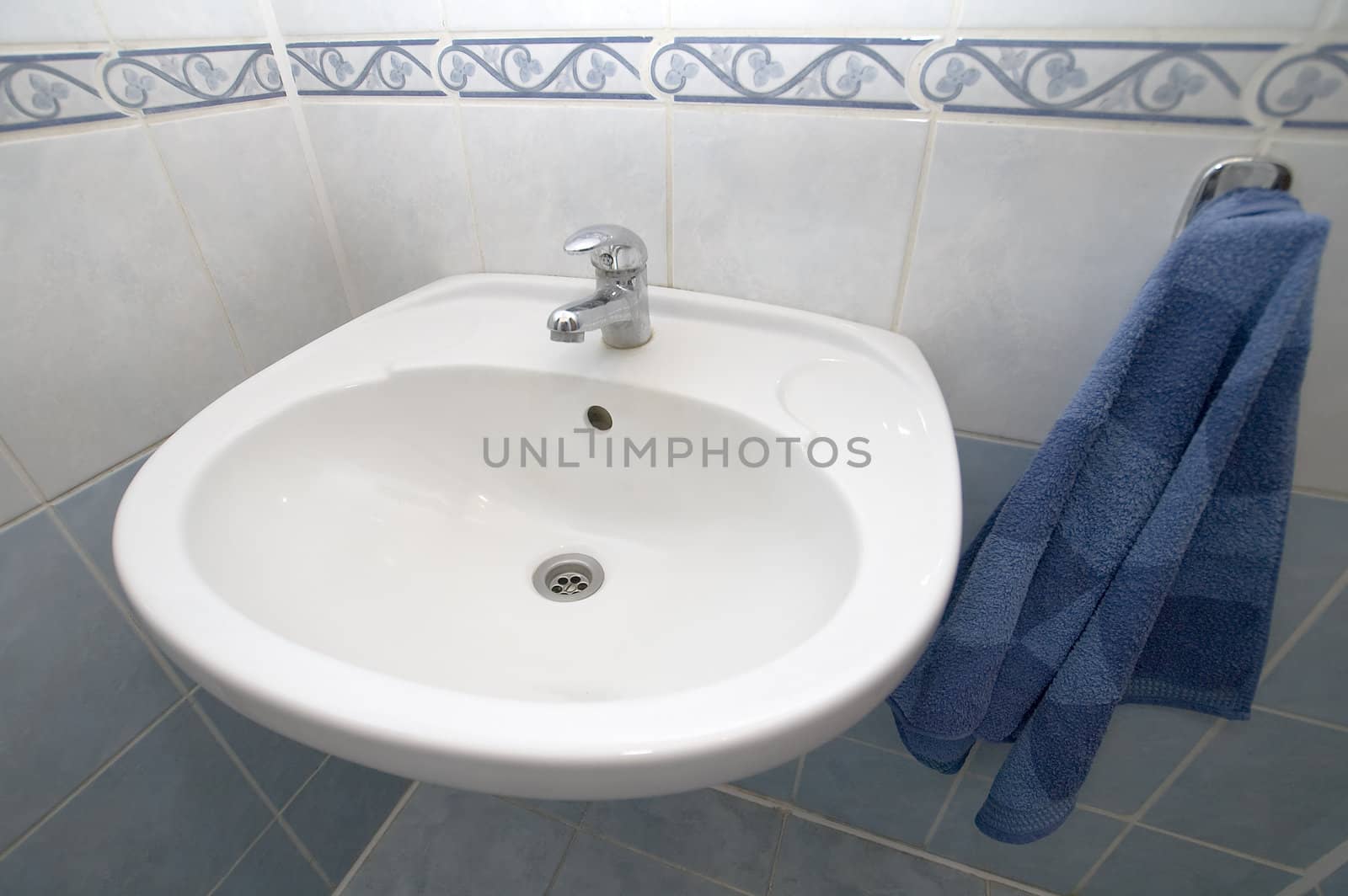 white basin detail photo, blue towel, tiled walls