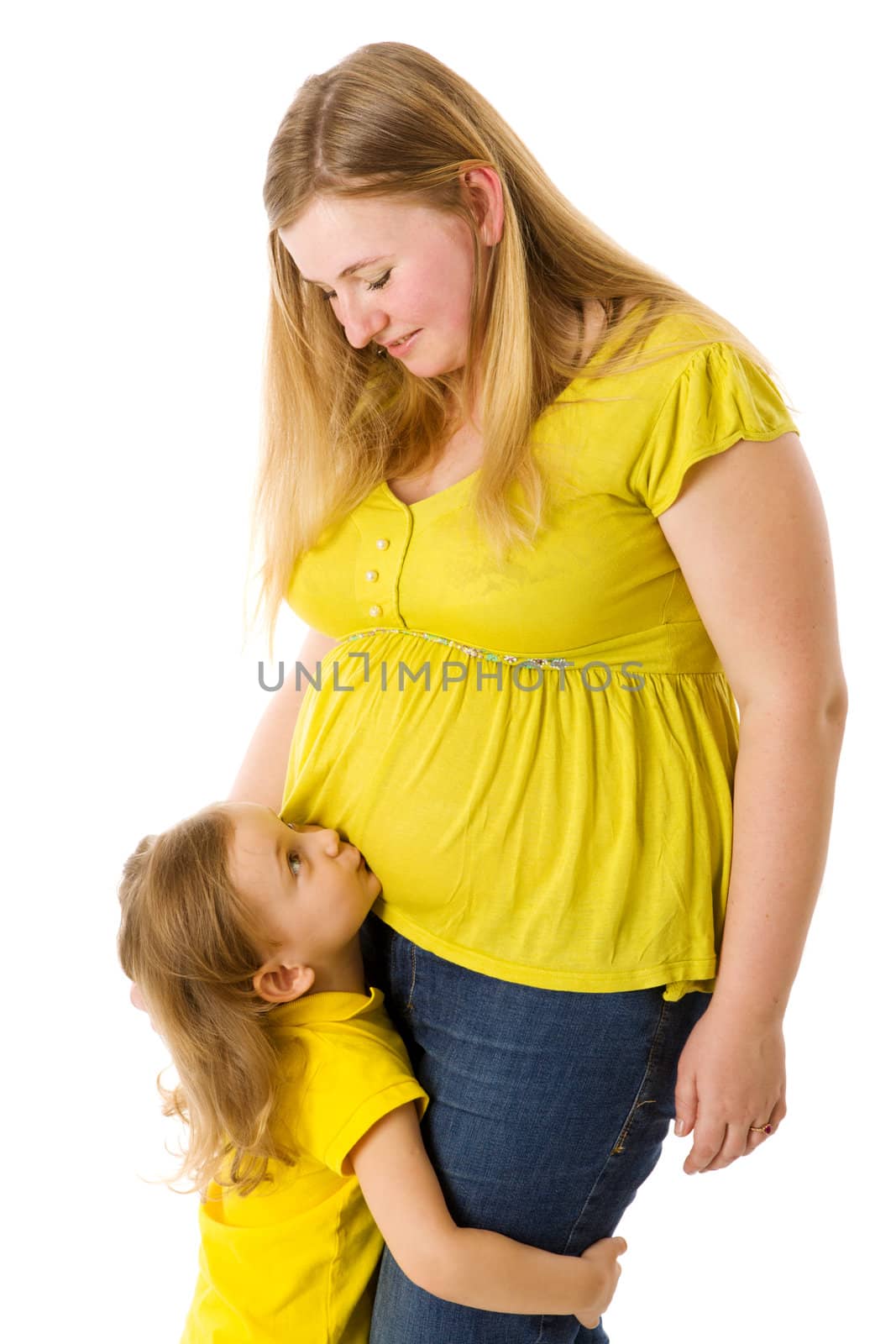 Daughter kissing pregnant mother's belly isolated on white