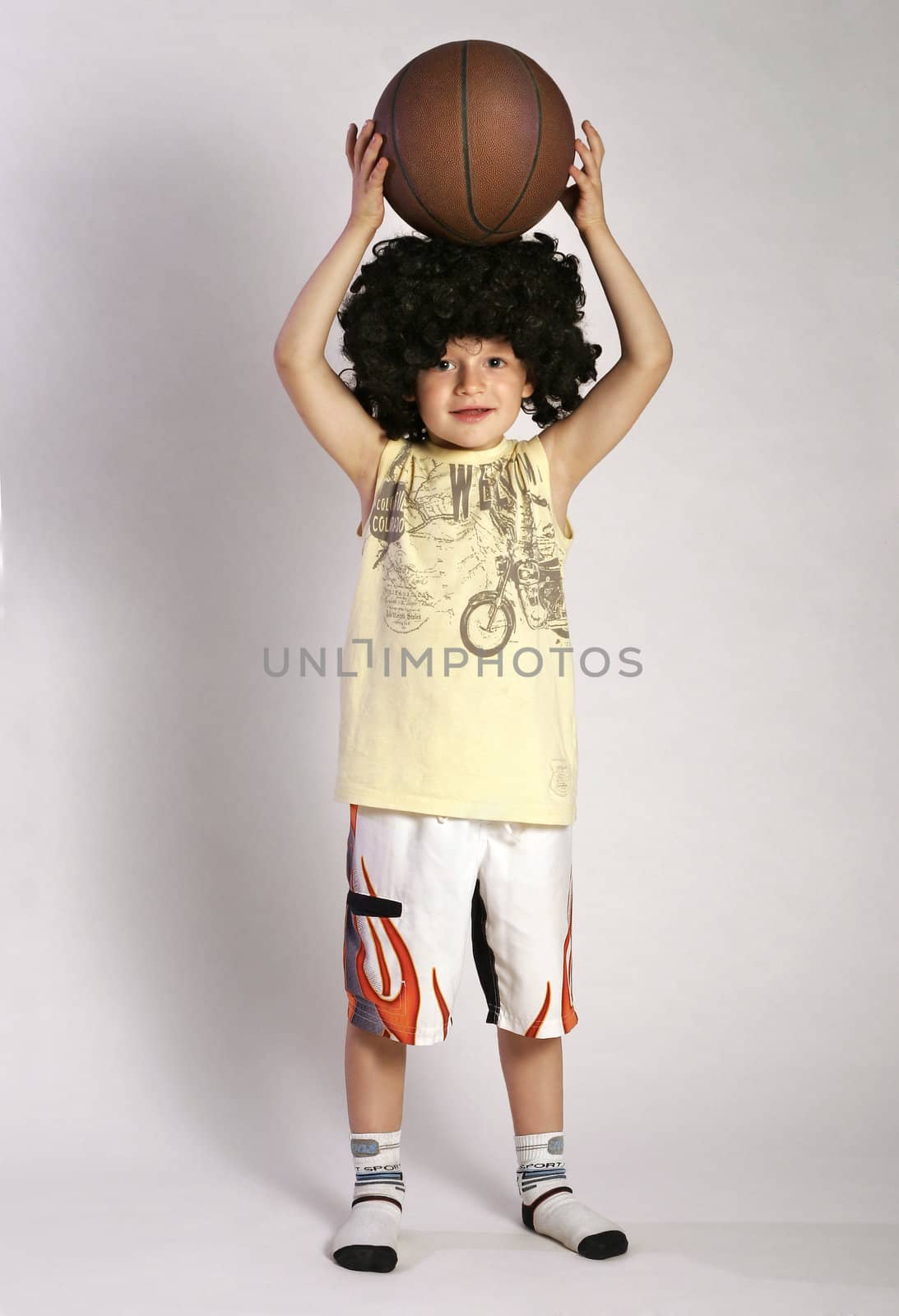 Boy in the wig put the ball on a head