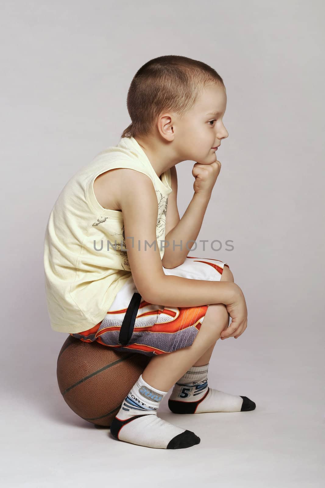 Child sitting on a ball and thinking