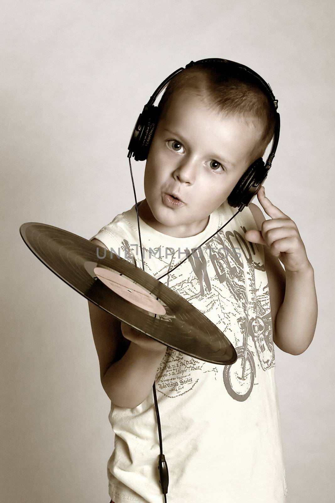 Child in headphones with grame playing dj
