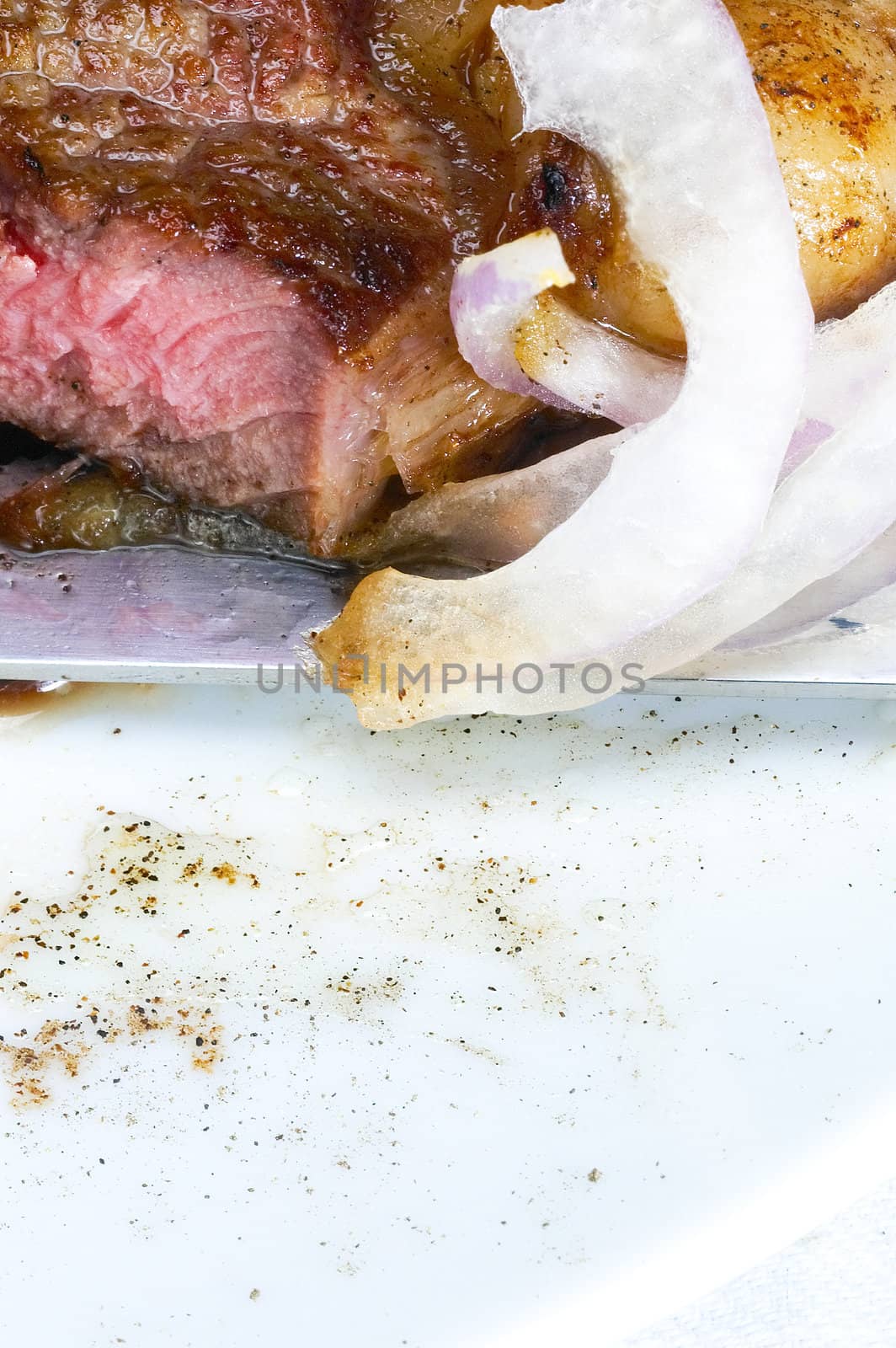 fresh juicy beef ribeye steak grilled sliced with onion beside